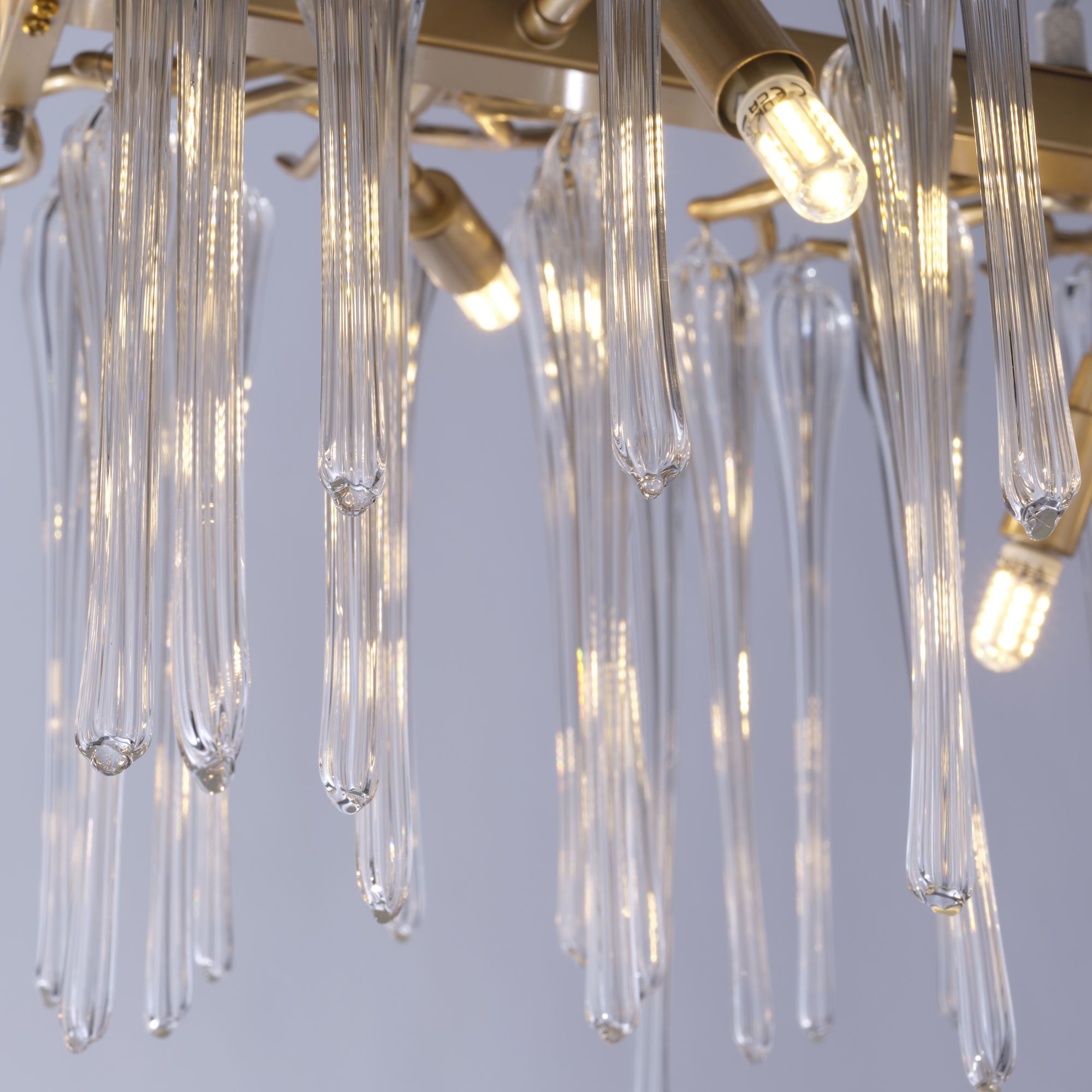 Close up of the Heritage pendant showing individual glass droplets and the small G9 filament bulbs glowing among them