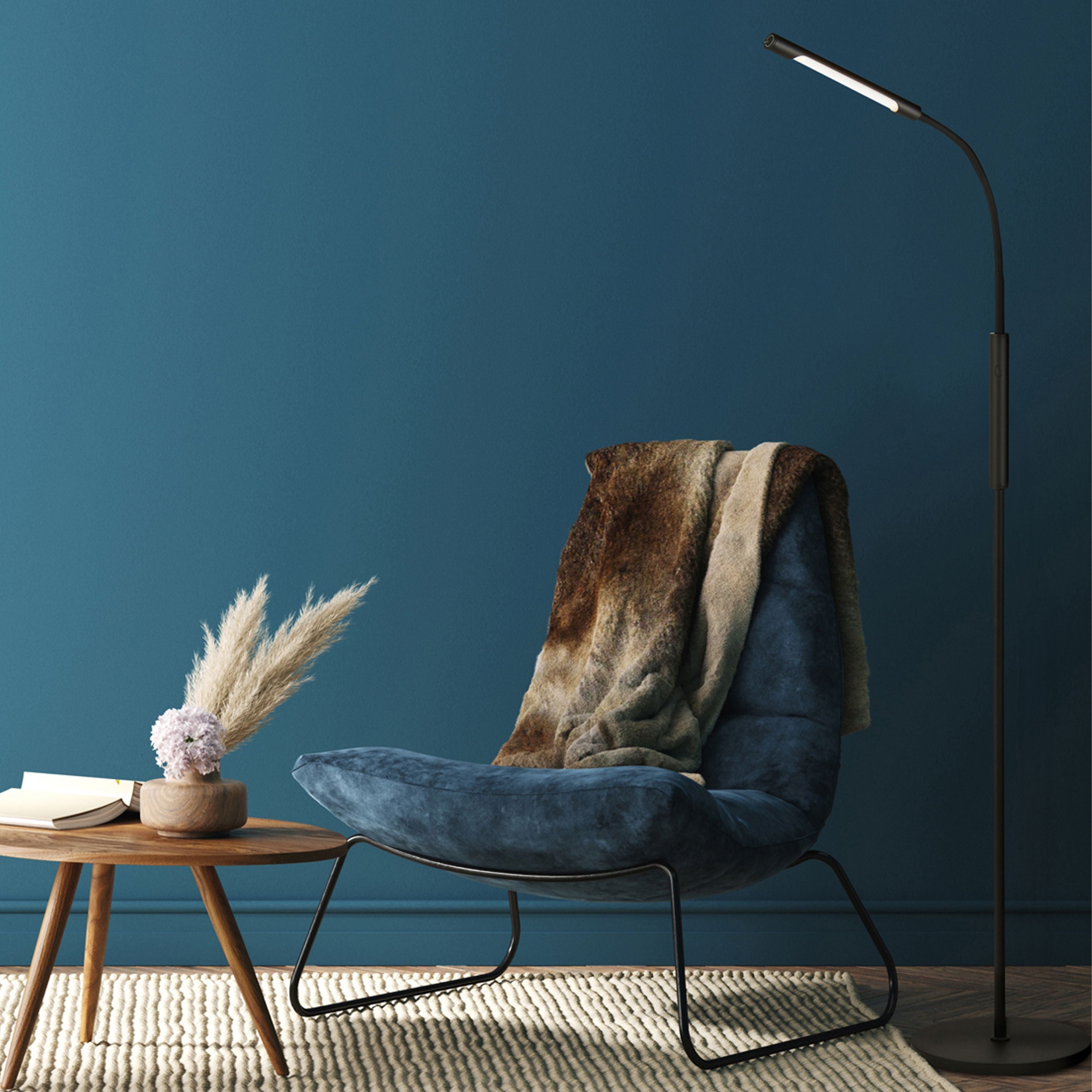 Searchlight Plume Rechargeable LED Floor Lamp styled in a dark teal room beside a blue chair