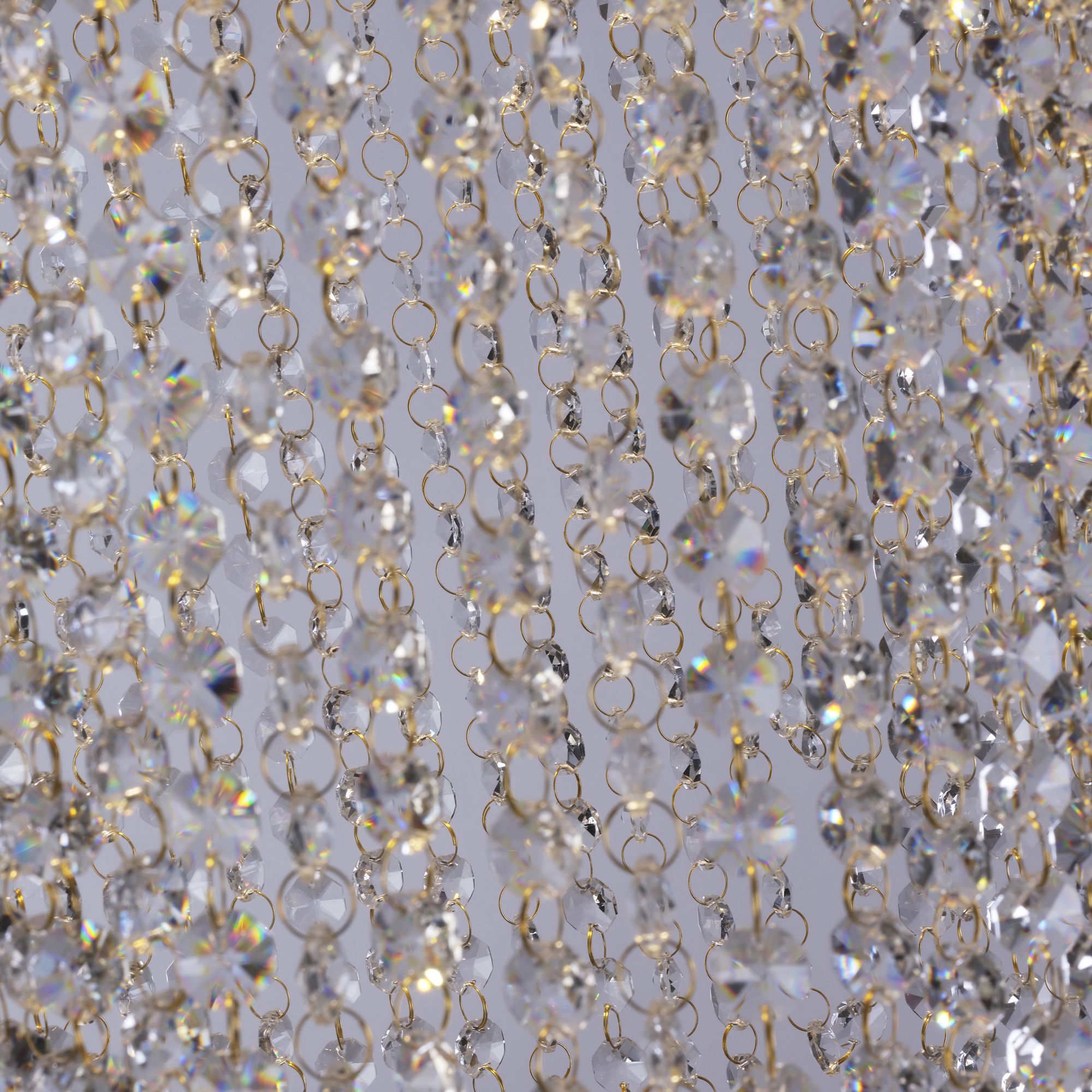 Close up of the Swoop pendant's clear crystal beaded strands linked with fine brass jump rings