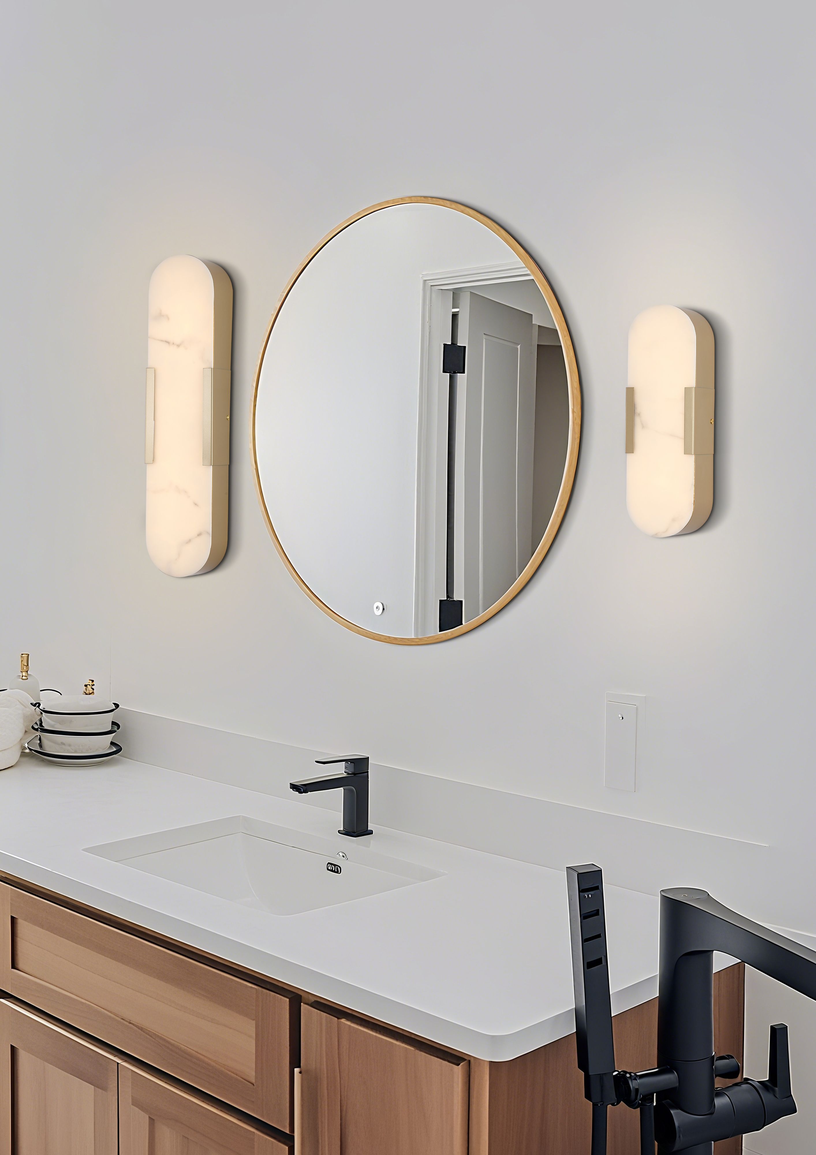 Pair of Searchlight Opaline LED wall lights in matt gold flanking a round wood framed mirror above a wooden bathroom vanity