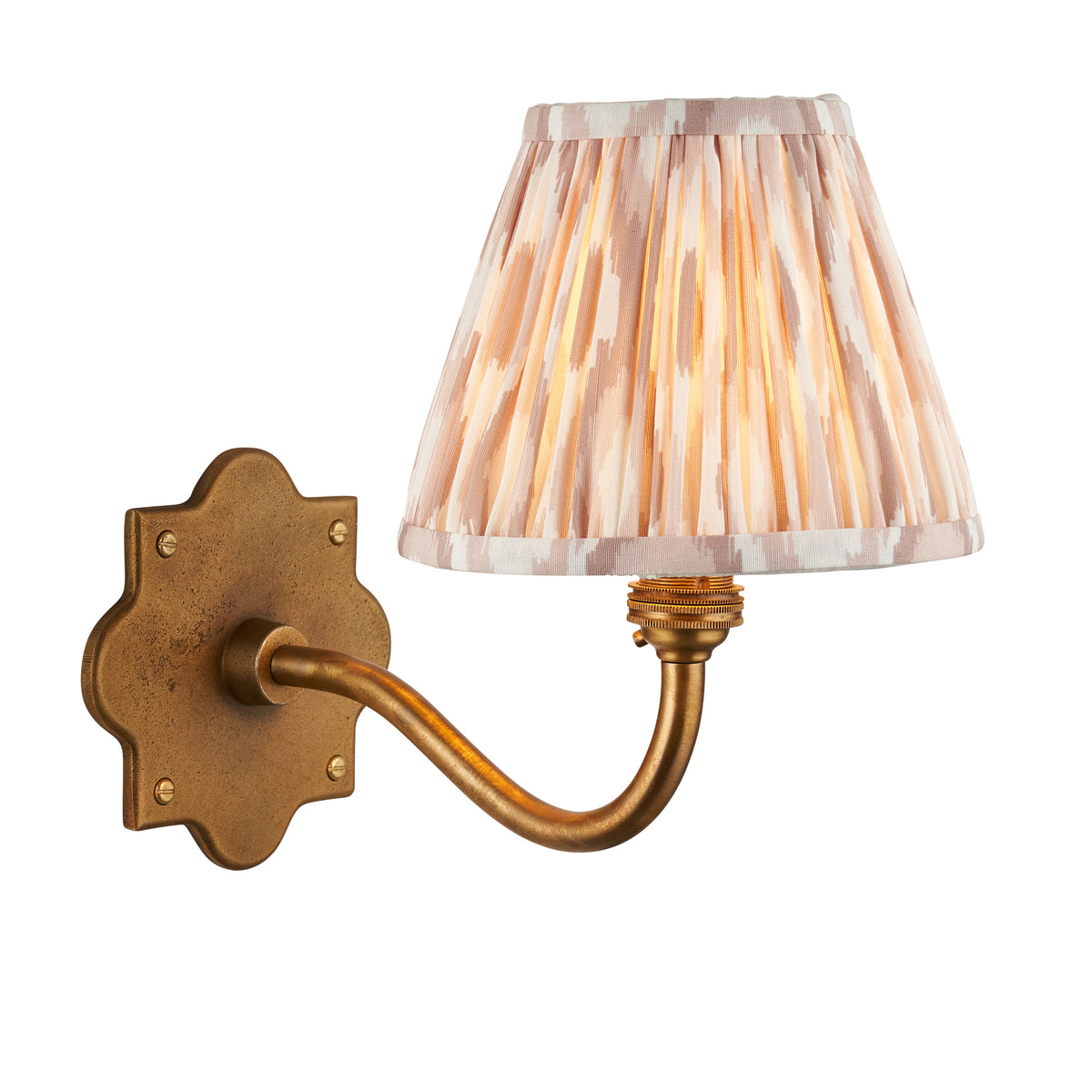 Endon Anvil Curve wall light in antique brass with a neutral ikat pleated shade, shown lit on a plain white background