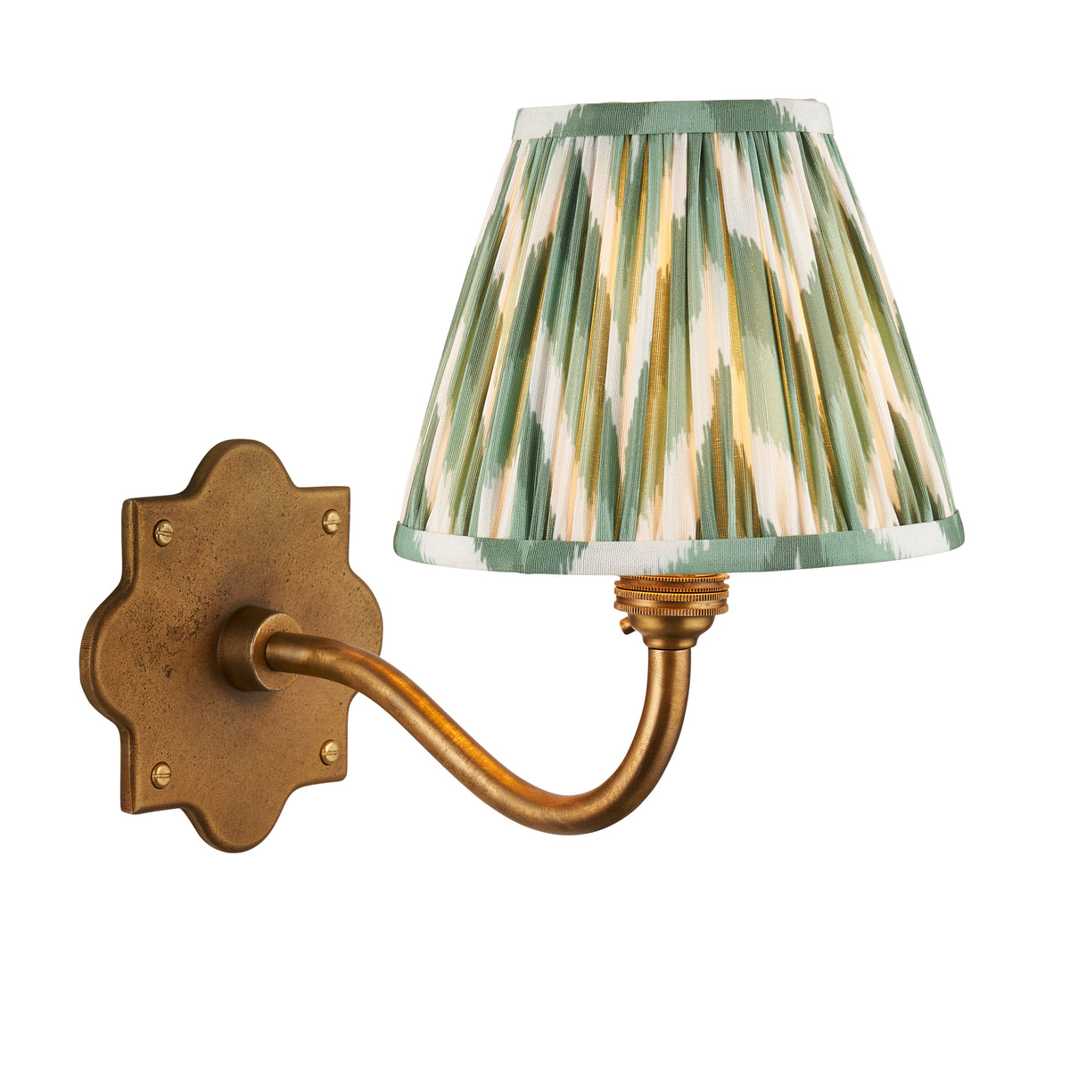Endon Anvil Curve wall light lit, cut out on white, antique brass scalloped backplate and curved arm with Cotswold green zigzag pleated shade