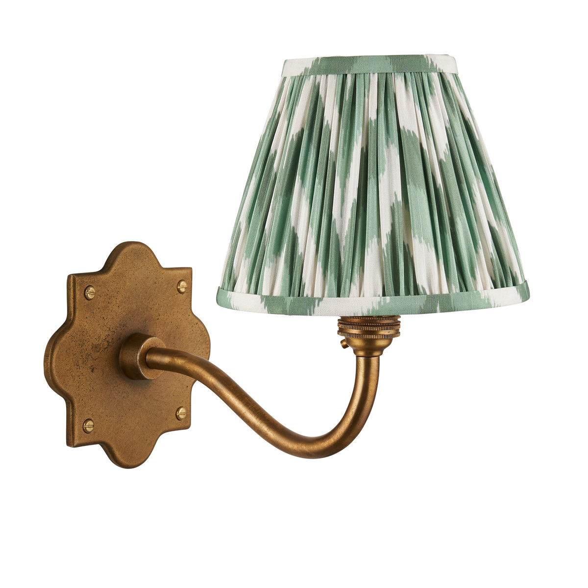 Endon Anvil Curve wall light unlit, cut out on white, antique brass scalloped backplate, curved arm and green zigzag pleated shade