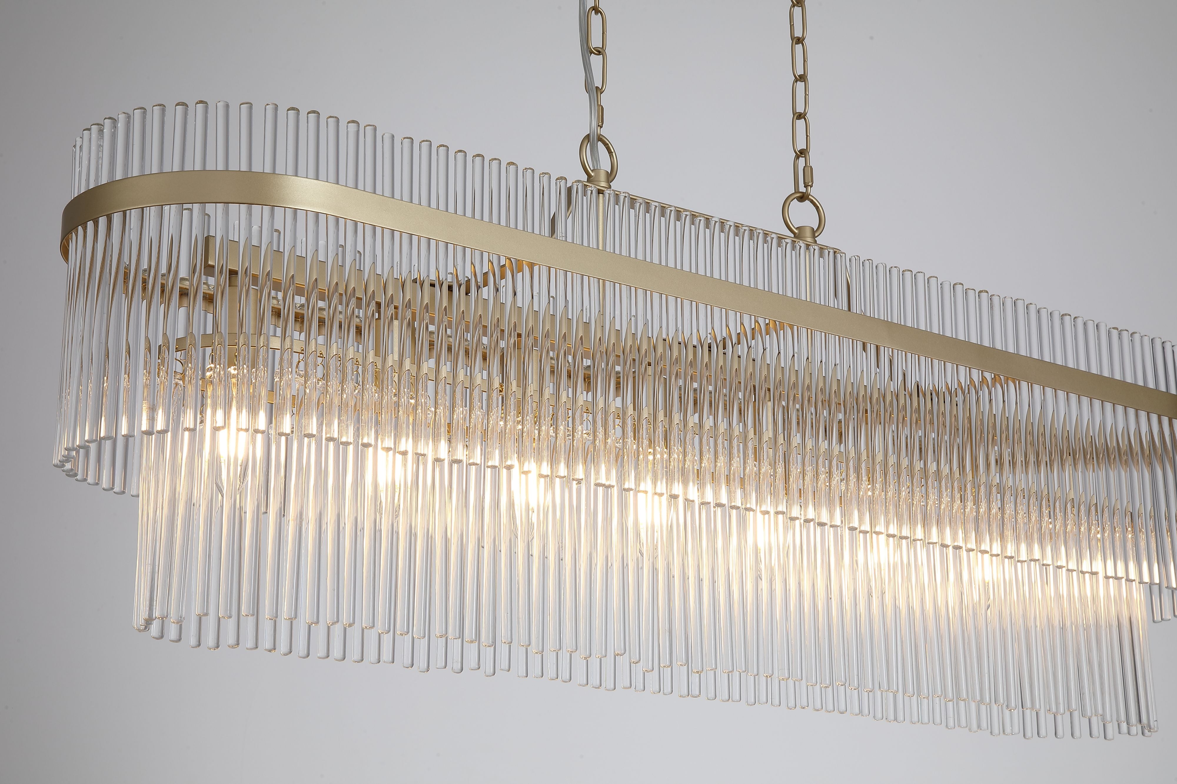 Close up of the Lara oval pendant's gold frame and clear glass rods with the candle bulbs glowing inside