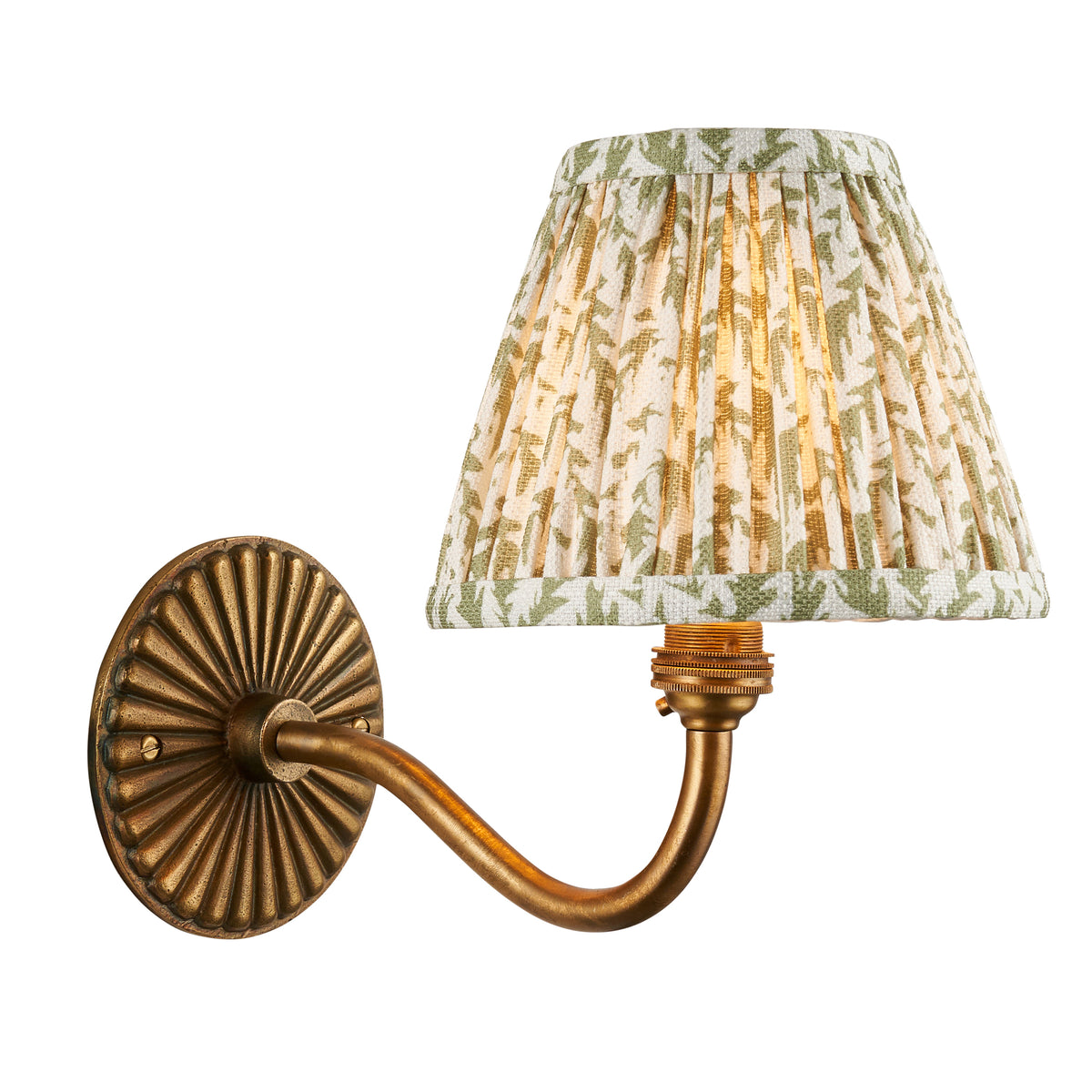 Endon Dahlia Curve antique brass wall light lit, cut out on white, fluted backplate, curved arm and green leaf print pleated shade