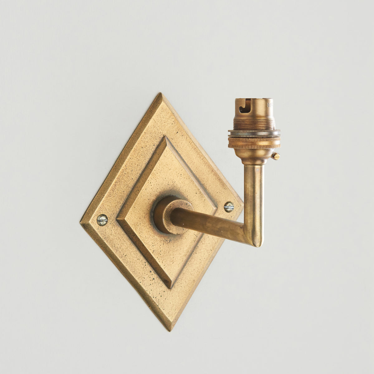 Close up of the Endon Diamond Angle antique brass diamond backplate, angled arm and bare B22 lamp holder without the shade