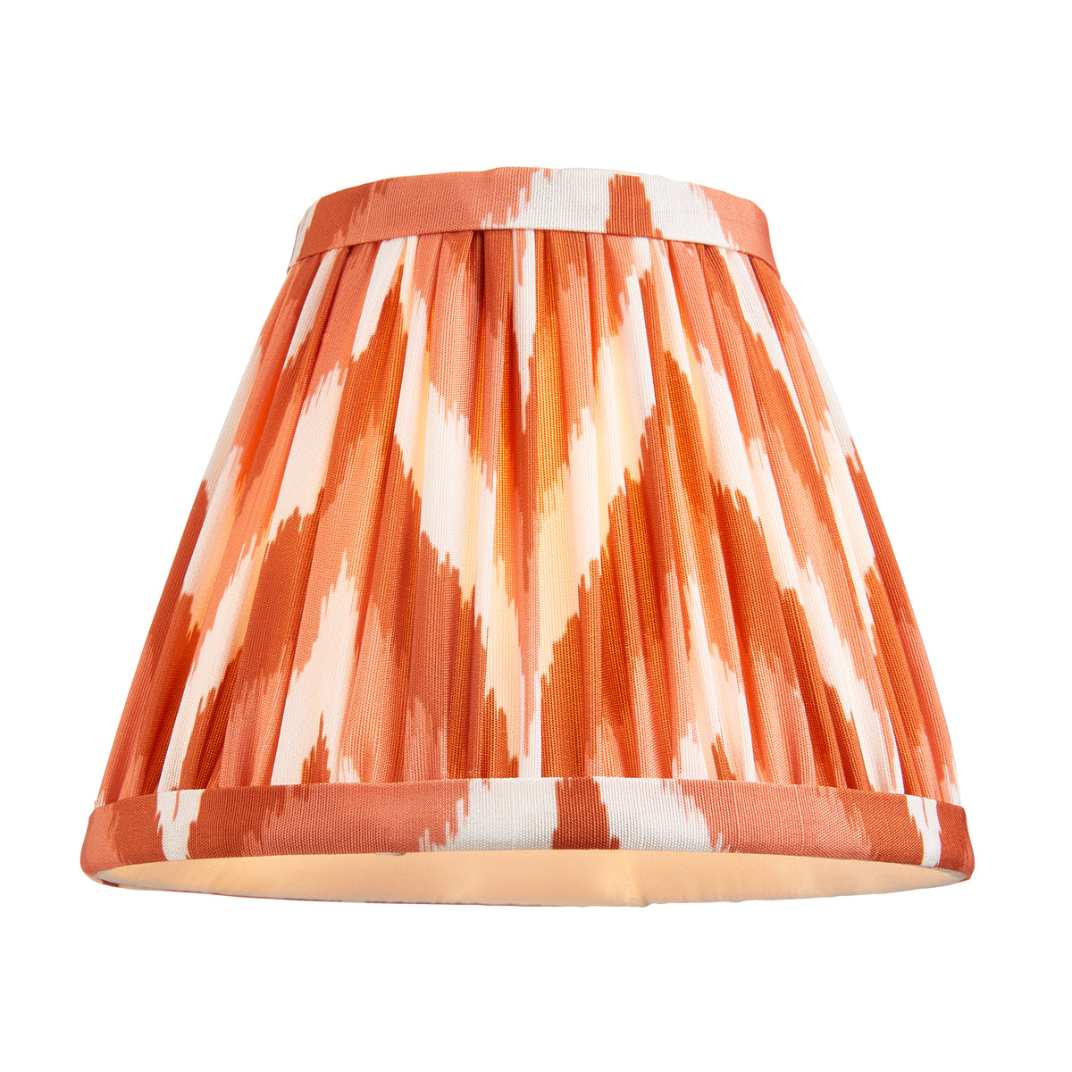 Endon 16cm apricot orange zigzag pleated lamp shade on its own, lit from inside, cut out on a white background