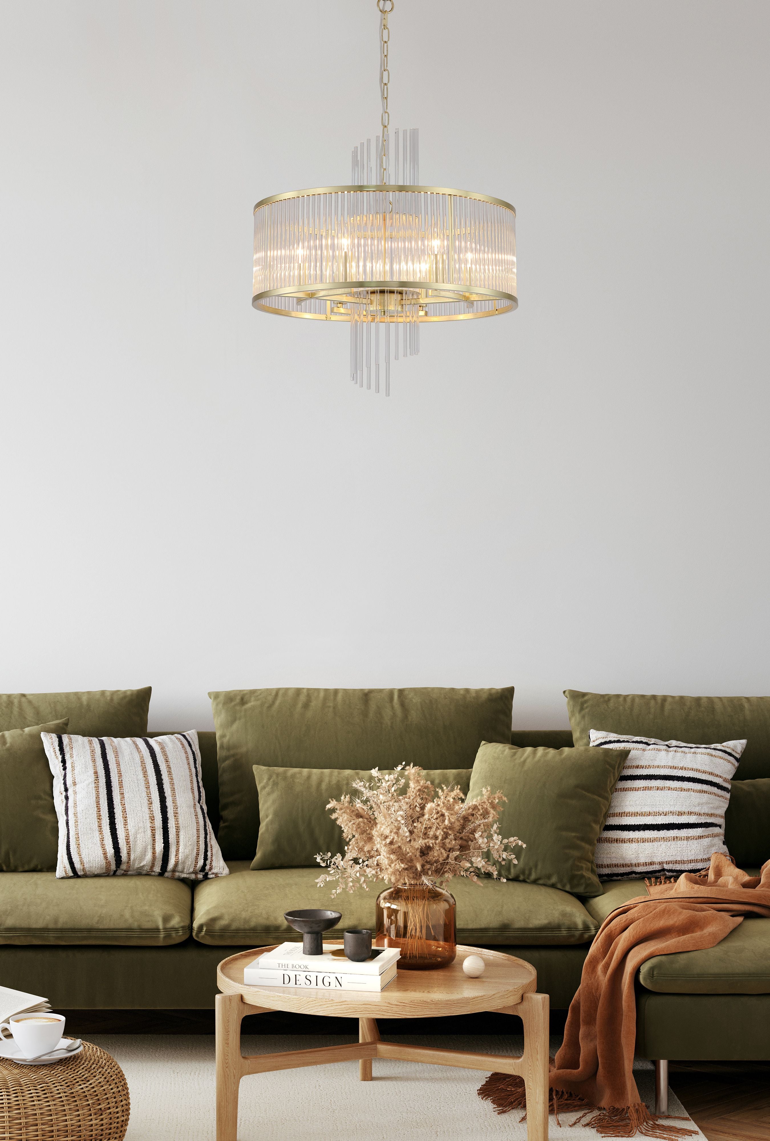 Searchlight Lara 6 light pendant in gold and clear glass hanging above a green velvet sofa and wooden coffee table in a styled living room