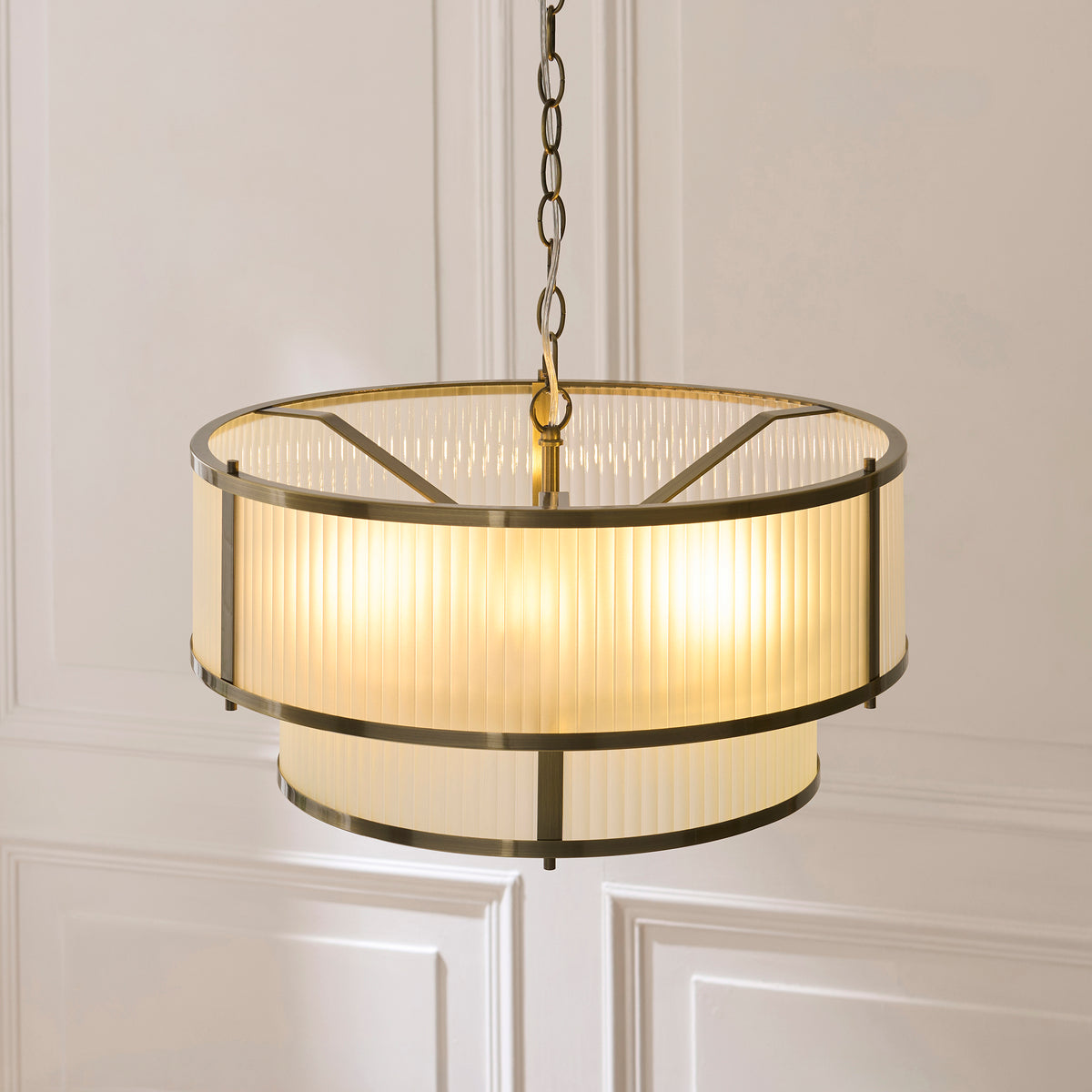 Close up lit shot of the Endon Ridgeton 5 light tiered pendant in antique brass showing the two tier frosted ribbed glass drums