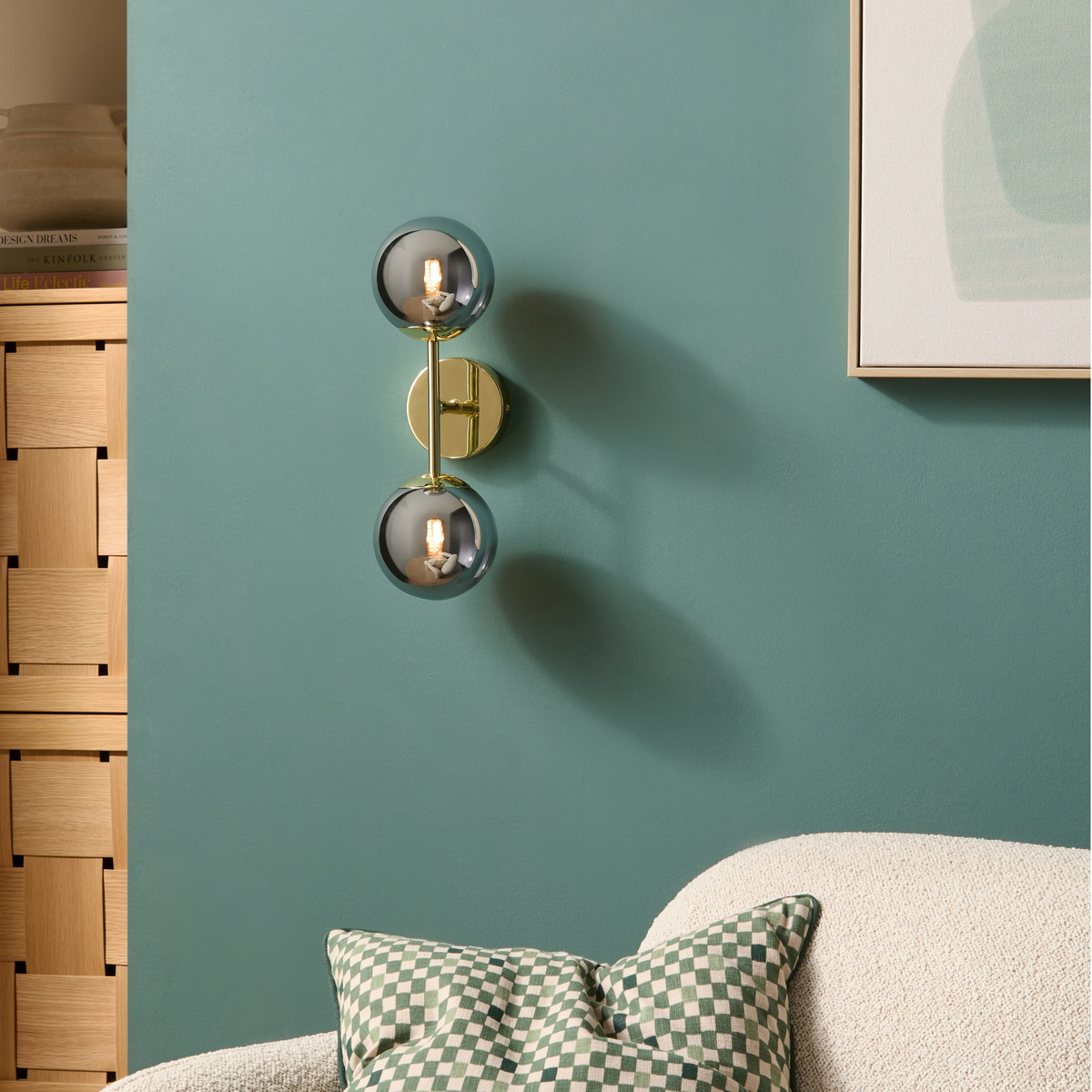 MADE.COM Globe wall light in polished brass with two smoke grey lustre globes, lifestyle shot on a teal wall