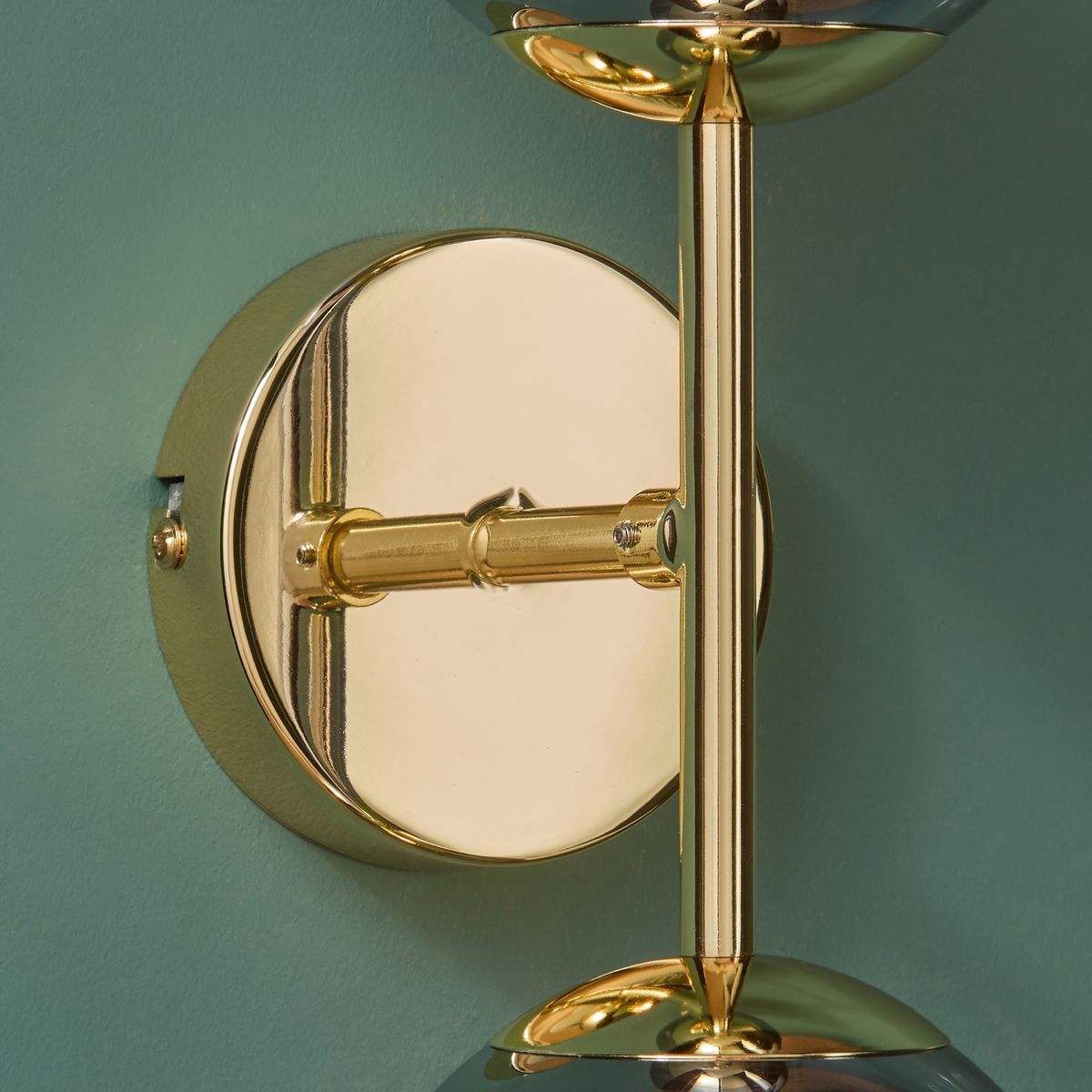 MADE Globe wall light close up of the polished brass round backplate and arm