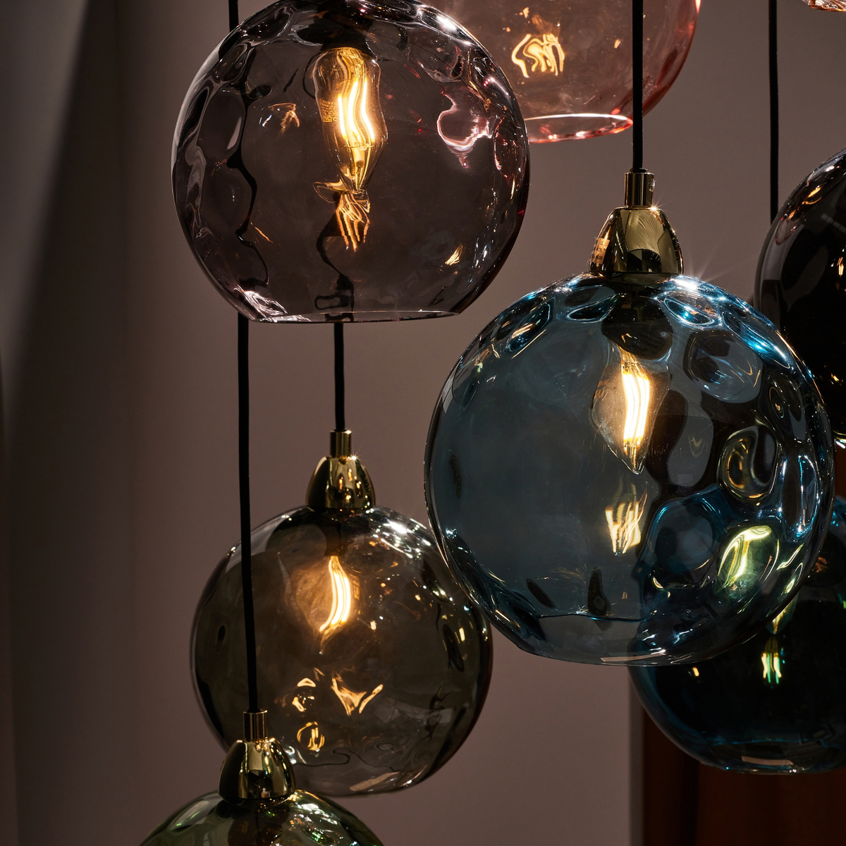 MADE Ilaria cluster pendant close up of dimpled blue and smoke glass shades lit at low level