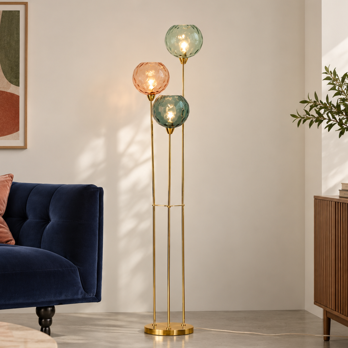 MADE Ilaria floor lamp in polished brass with three dimpled glass shades, living room shot beside a navy sofa