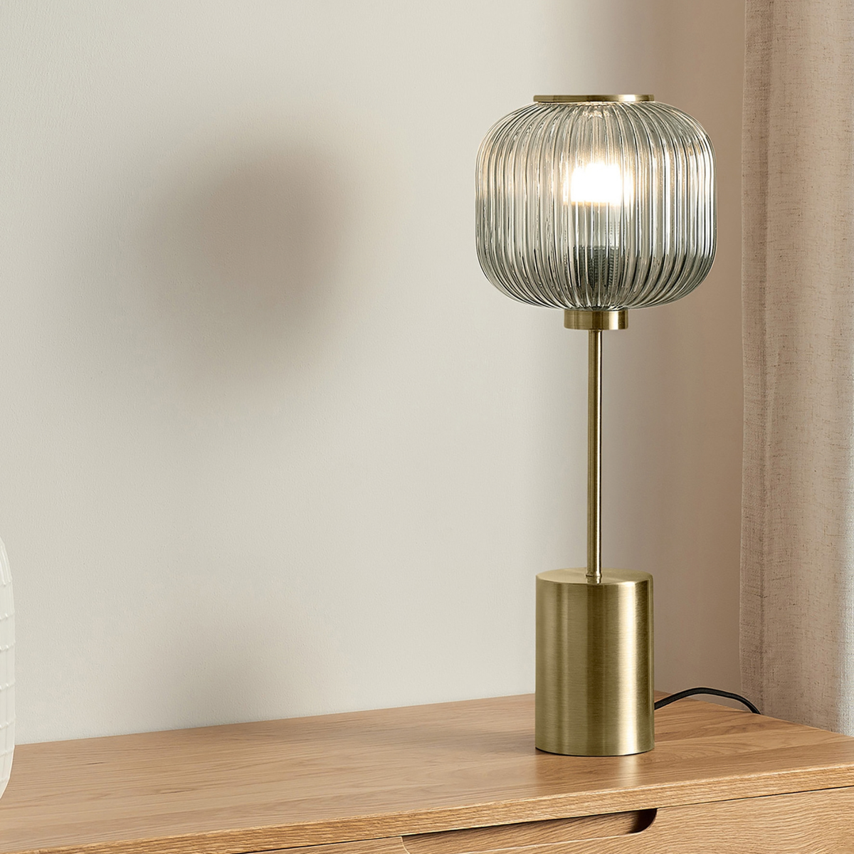 MADE.COM Briz large table lamp in brushed brass with ribbed grey glass shade, lifestyle shot on a sideboard