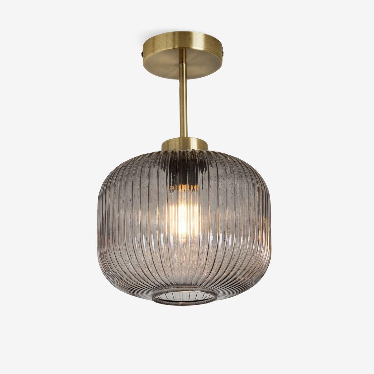 MADE Briz flush ceiling light in antique brass with ribbed grey glass shade, studio shot lit