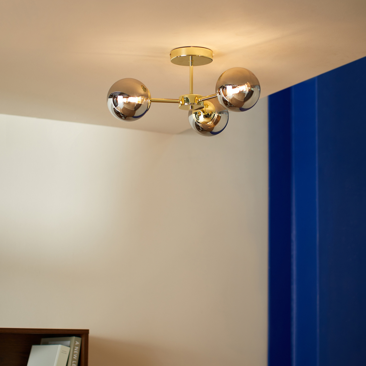 MADE.COM Globe 3 light flush ceiling light in polished brass with smoked grey lustre glass shades, lifestyle shot