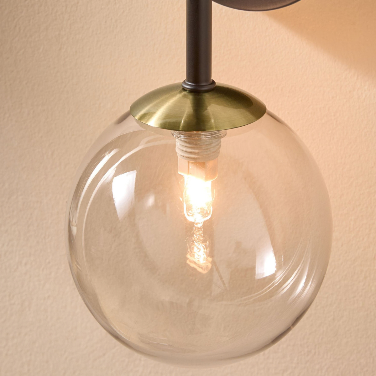 Detail of clear glass globe with halogen bulb on MADE Globe wall light