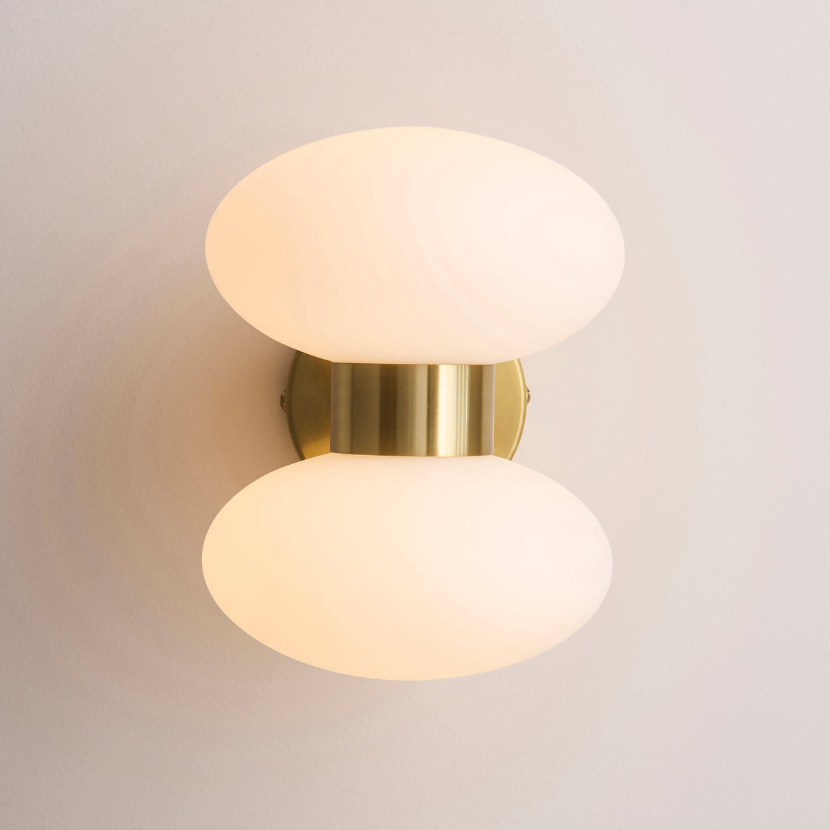 Plain product shot on a white background of the Endon Rossano 2 light wall light in warm brass with opal glass shades, lit, front view