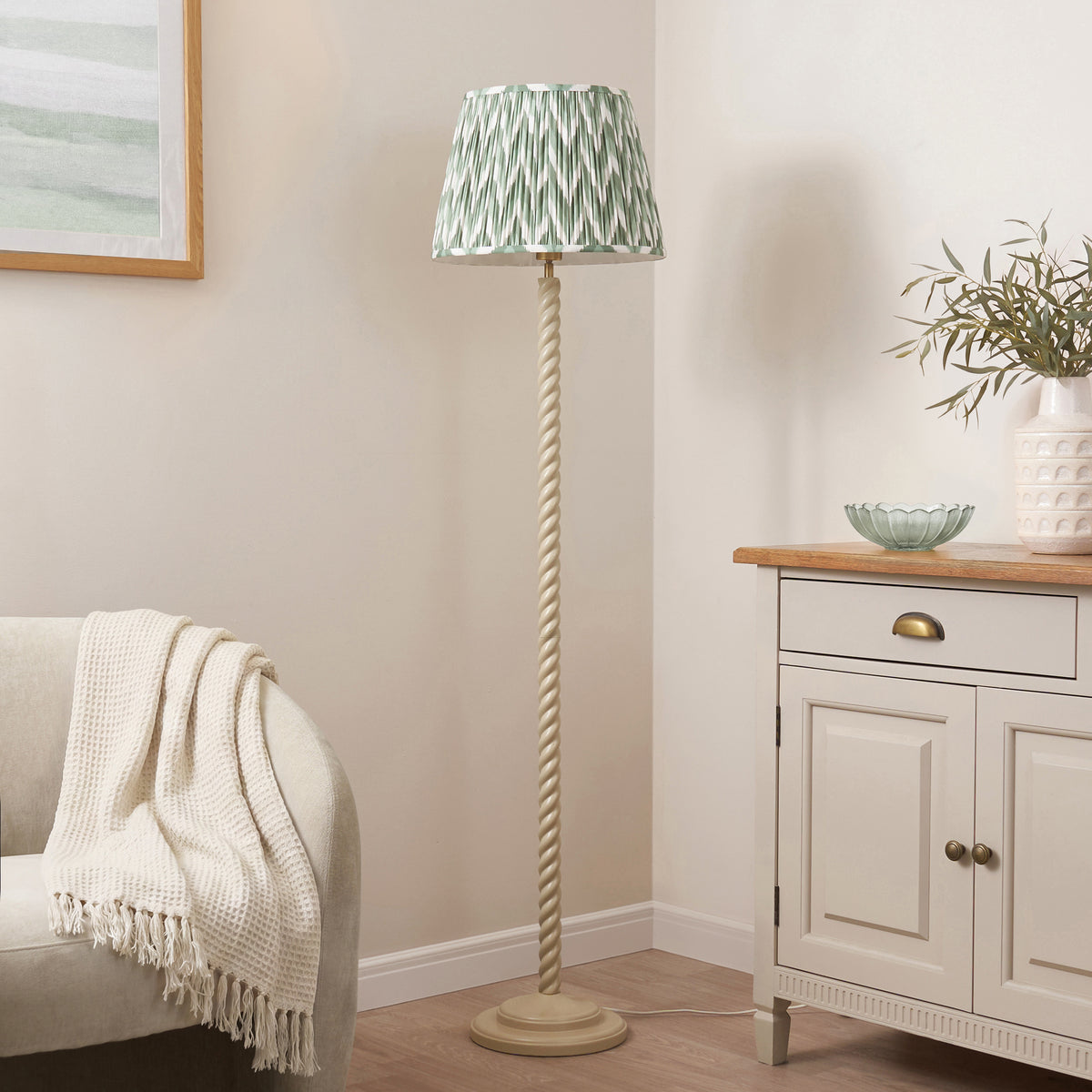Endon Twist floor lamp unlit in a cream room, almond white twisted stem and Cotswold green zigzag shade beside a sofa and sideboard