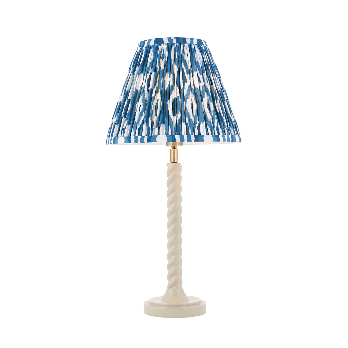 Endon Twist table lamp with a satin almond white barley twist base and a marlin blue ikat pleated shade, lit, on a white background