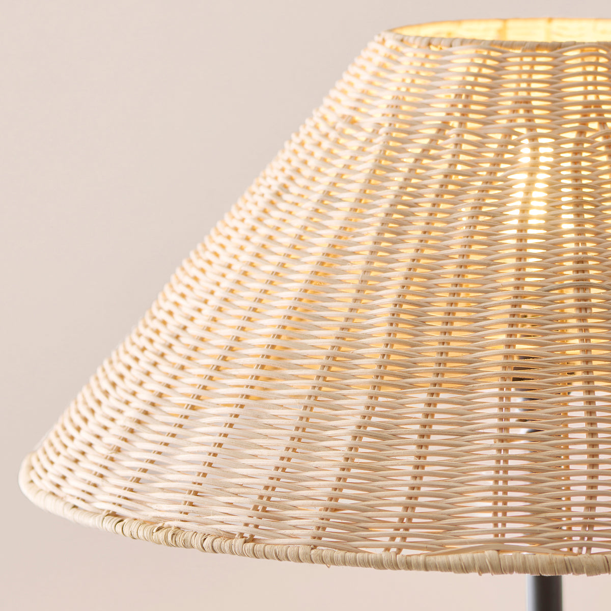 Close up detail of the hand woven natural rattan shade on the Endon Arlo floor lamp, lit from inside