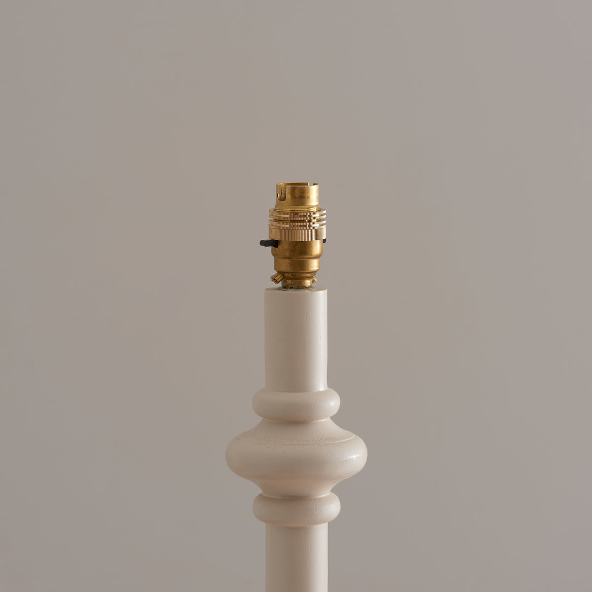 Close up of the brass B22 switched lamp holder on top of the Endon Carnaby floor lamp almond white turned wooden stem, shade removed