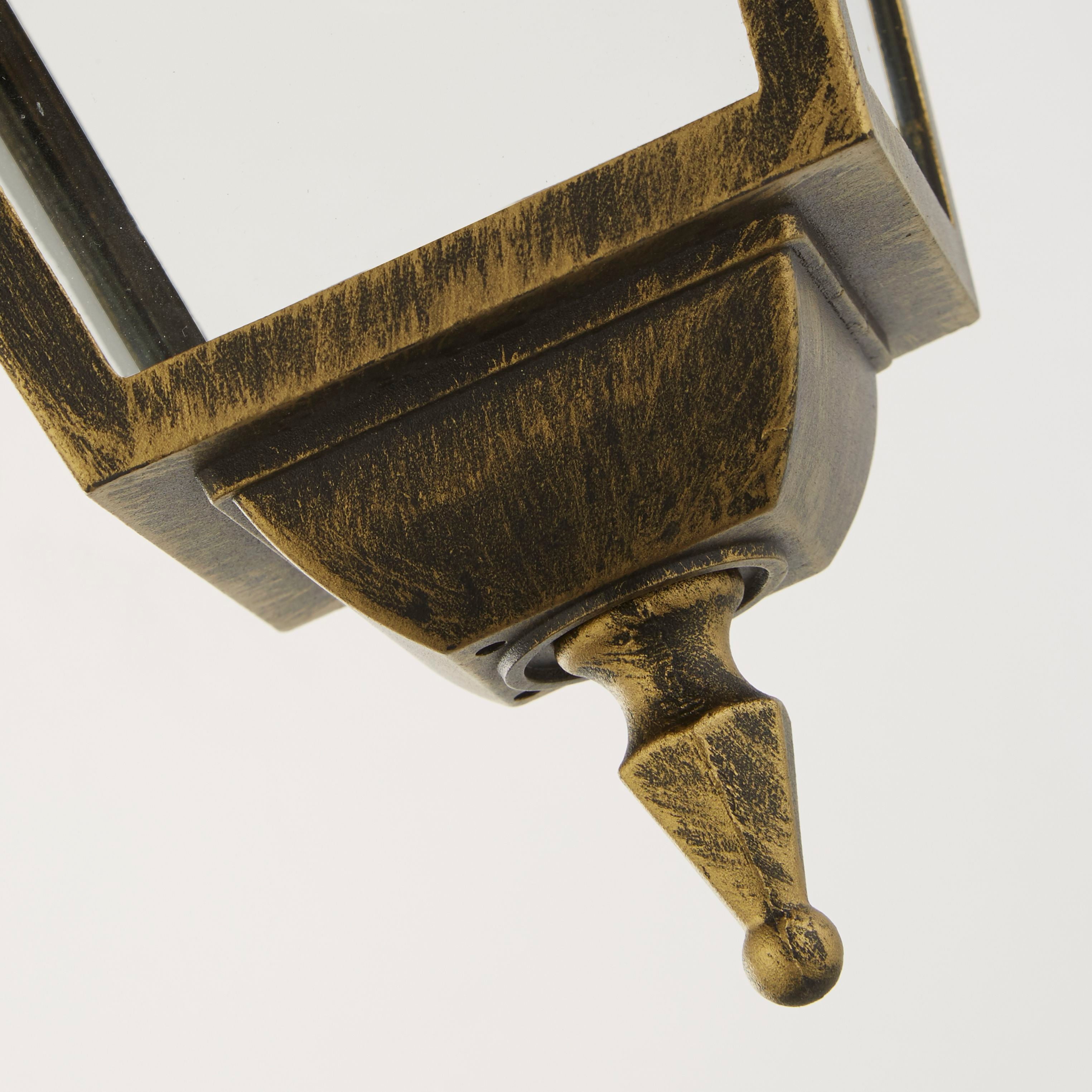 Close up of the New Orleans Pendant Lantern's decorative drop finial and roof detailing, showing the black and gold brushed finish
