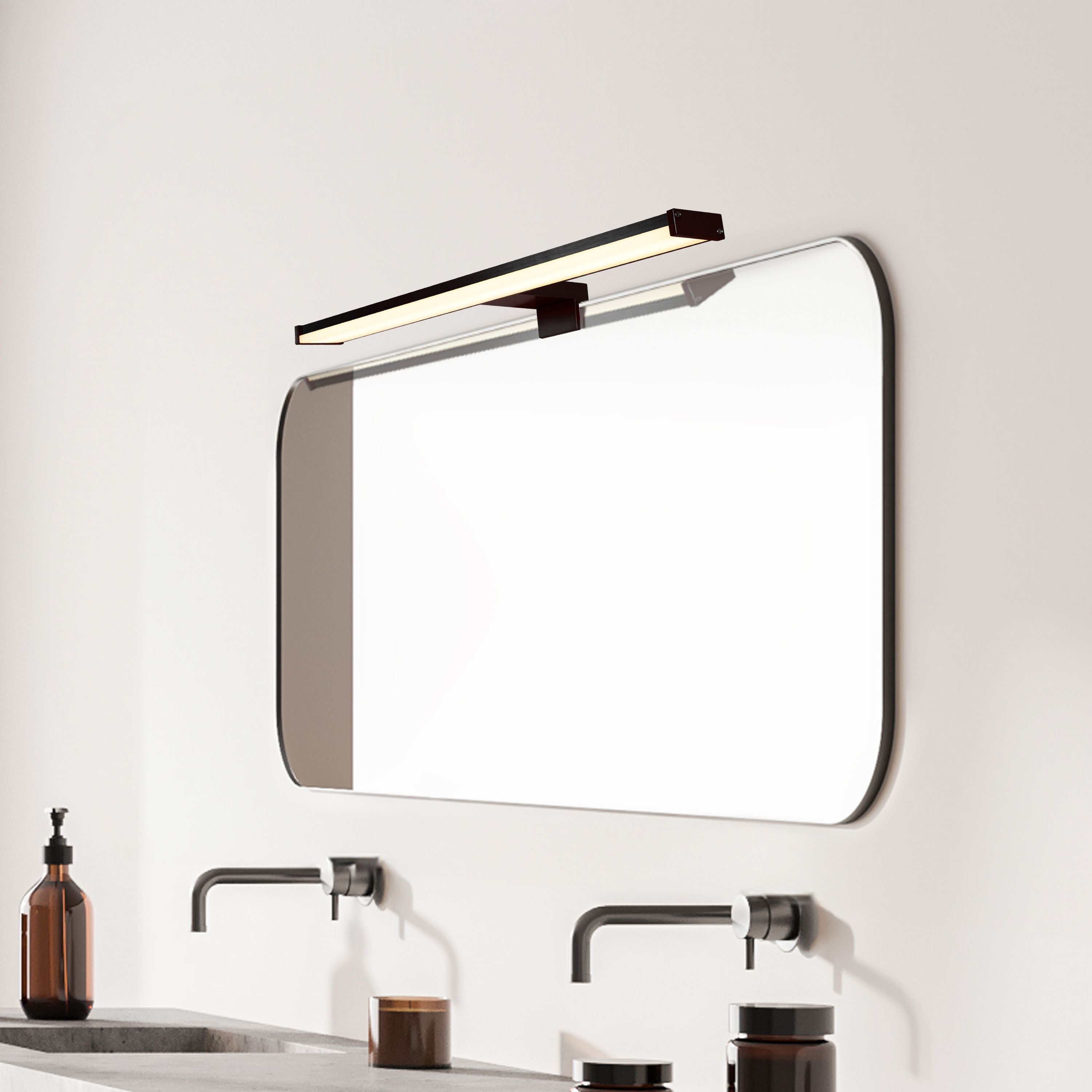 Kos matt black mirror light fixed above a bathroom mirror, styled room setting with taps below