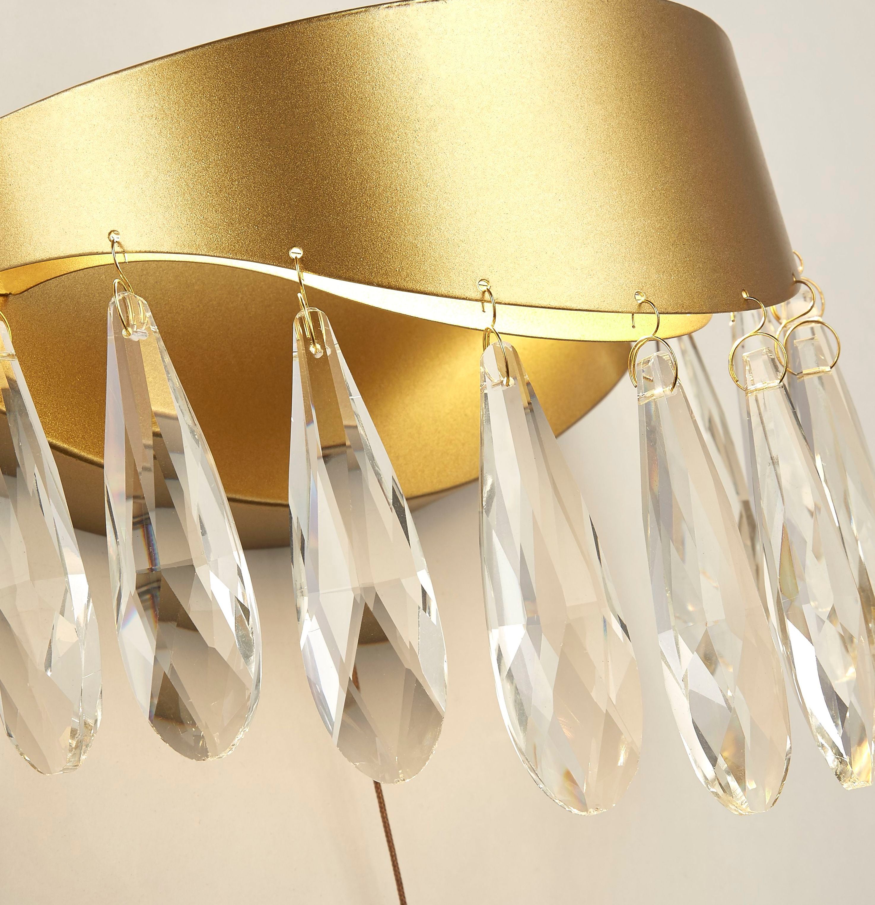 Close up of the crystal pear drops, gold rim and pull cord switch on the Jewel wall light