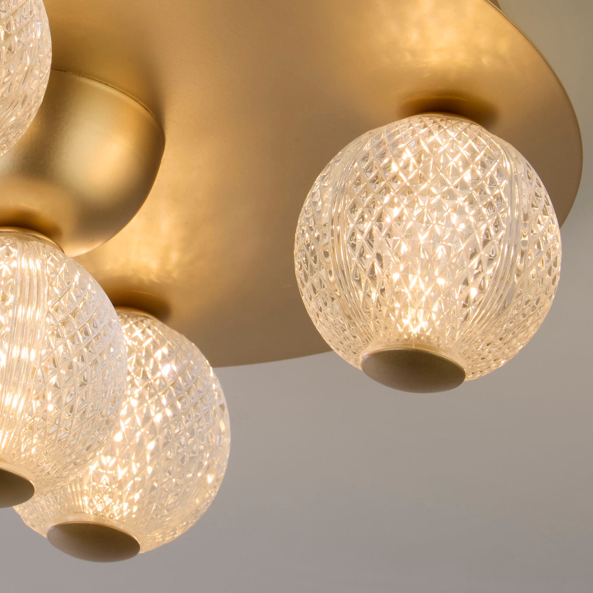 Close up detail of the Asteroid flush light's textured acrylic balls and gold backplate
