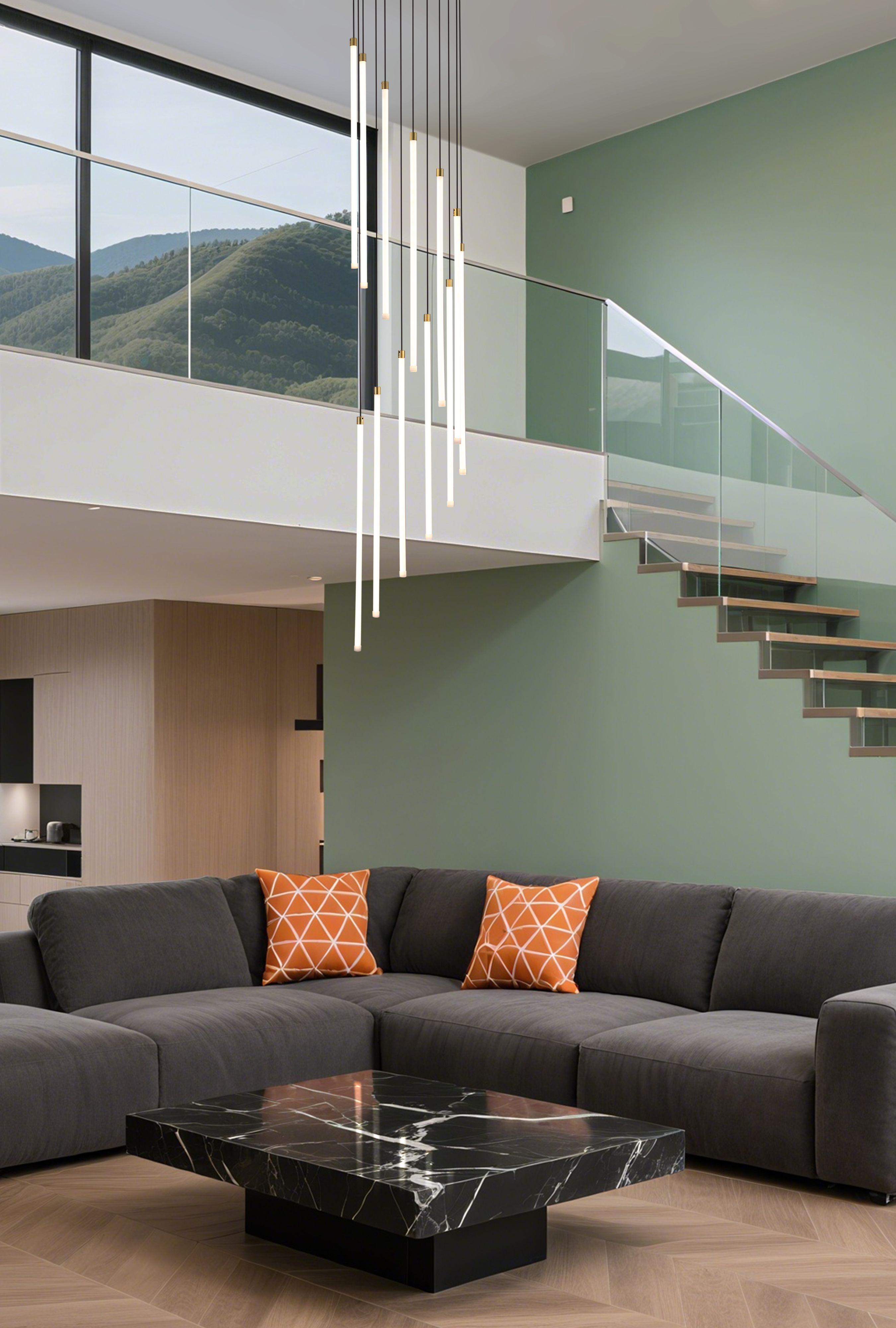 Searchlight Flare 12 light stairwell pendant in satin brass hanging above a staircase and living area, styled with a green feature wall and mountain view