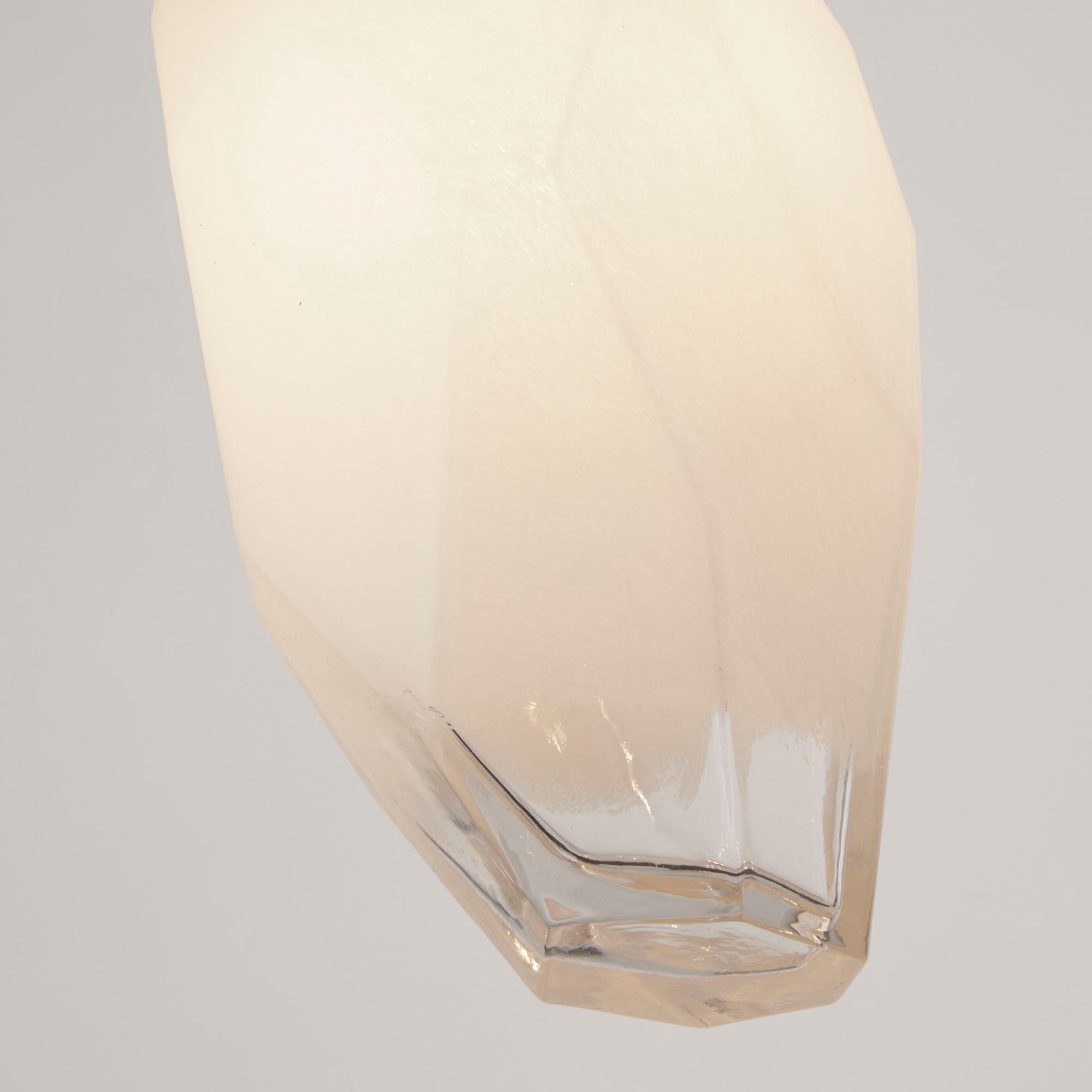 Close up of the Rocky pendant's faceted glass shade, showing the clear glass base beneath the white frosted upper section