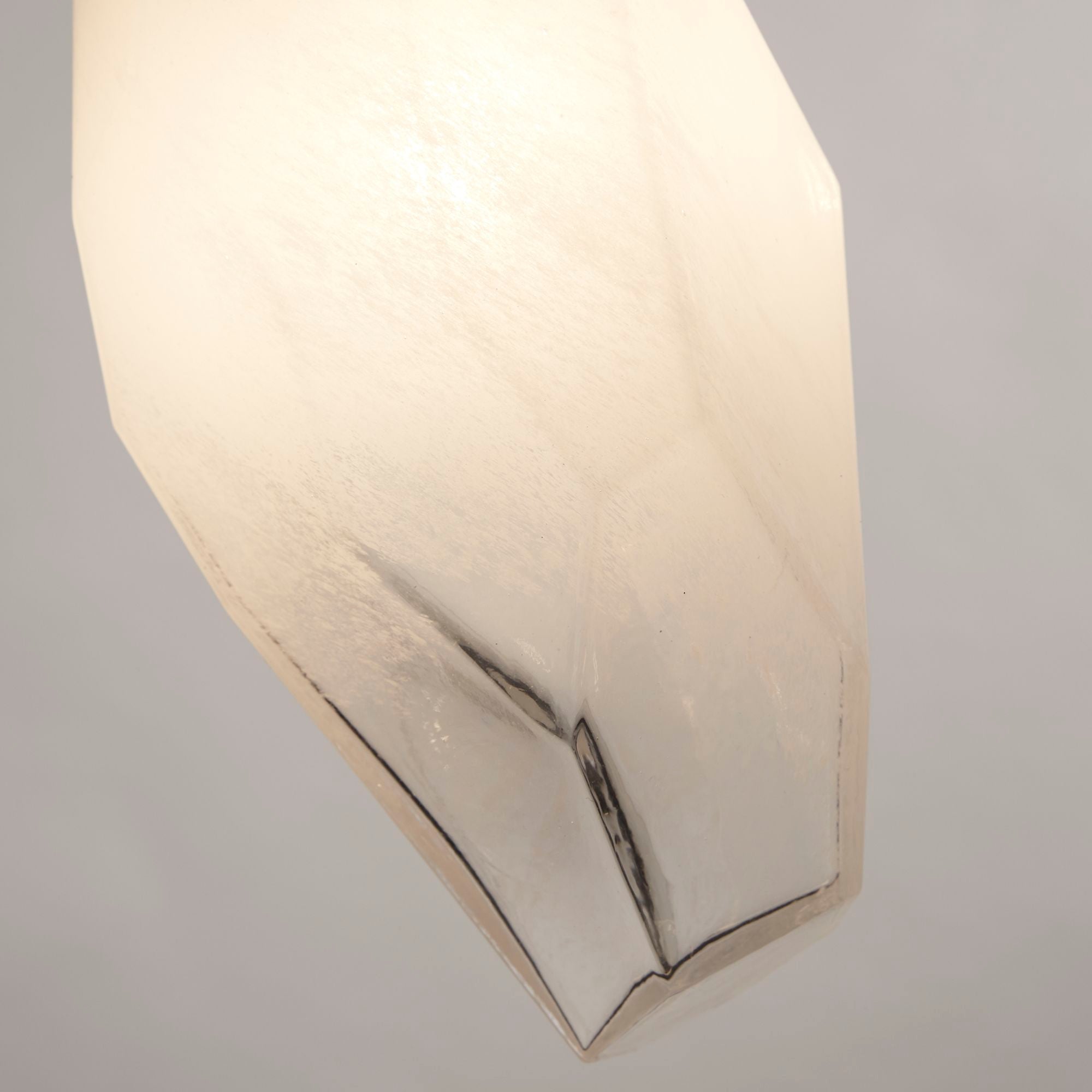 Close up of a Rocky bar pendant shade, showing the faceted glass edge and point where the frosted and clear glass meet