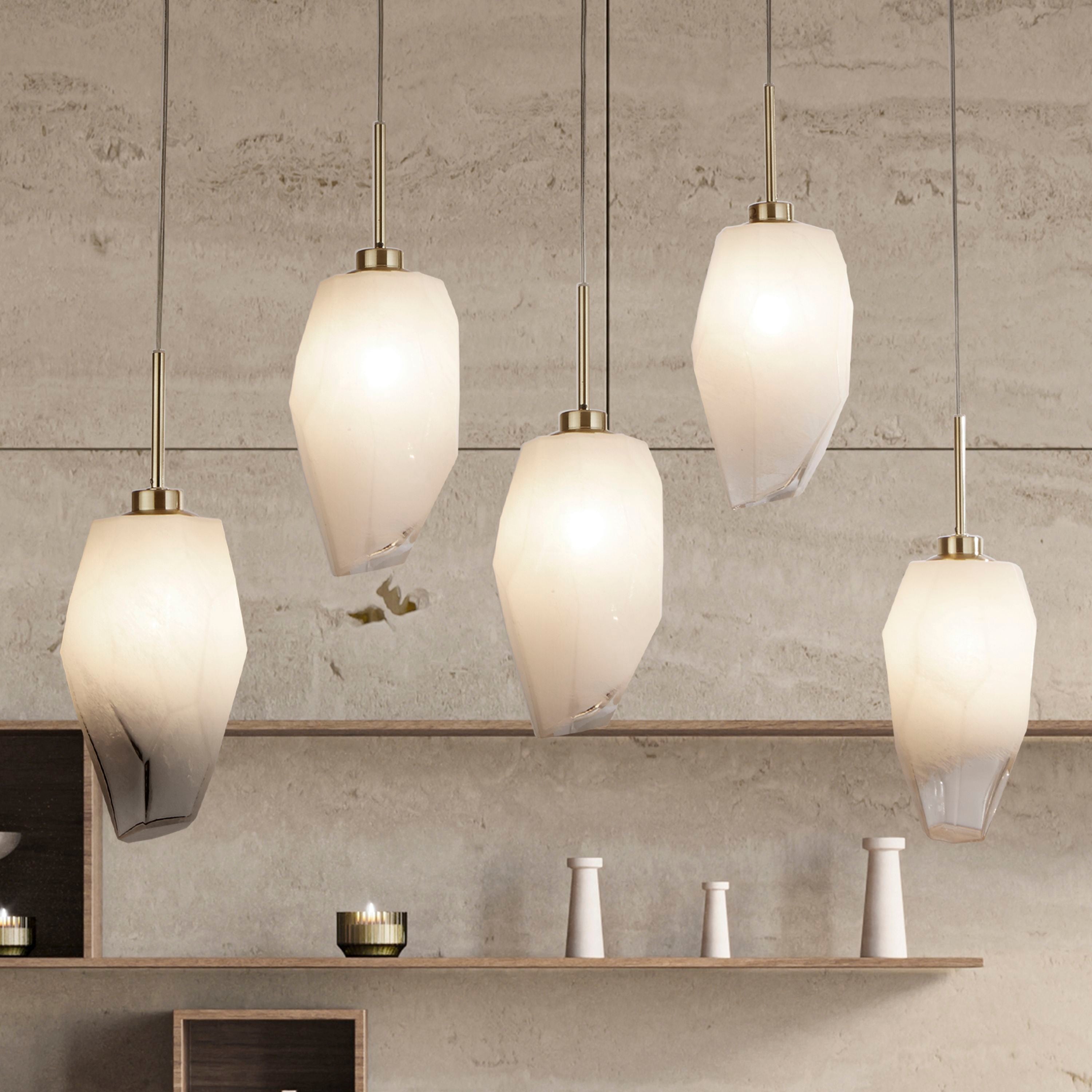 Rocky 5 light bar pendant hung above a shelf with candles and ceramic vases, five faceted shades staggered at different heights
