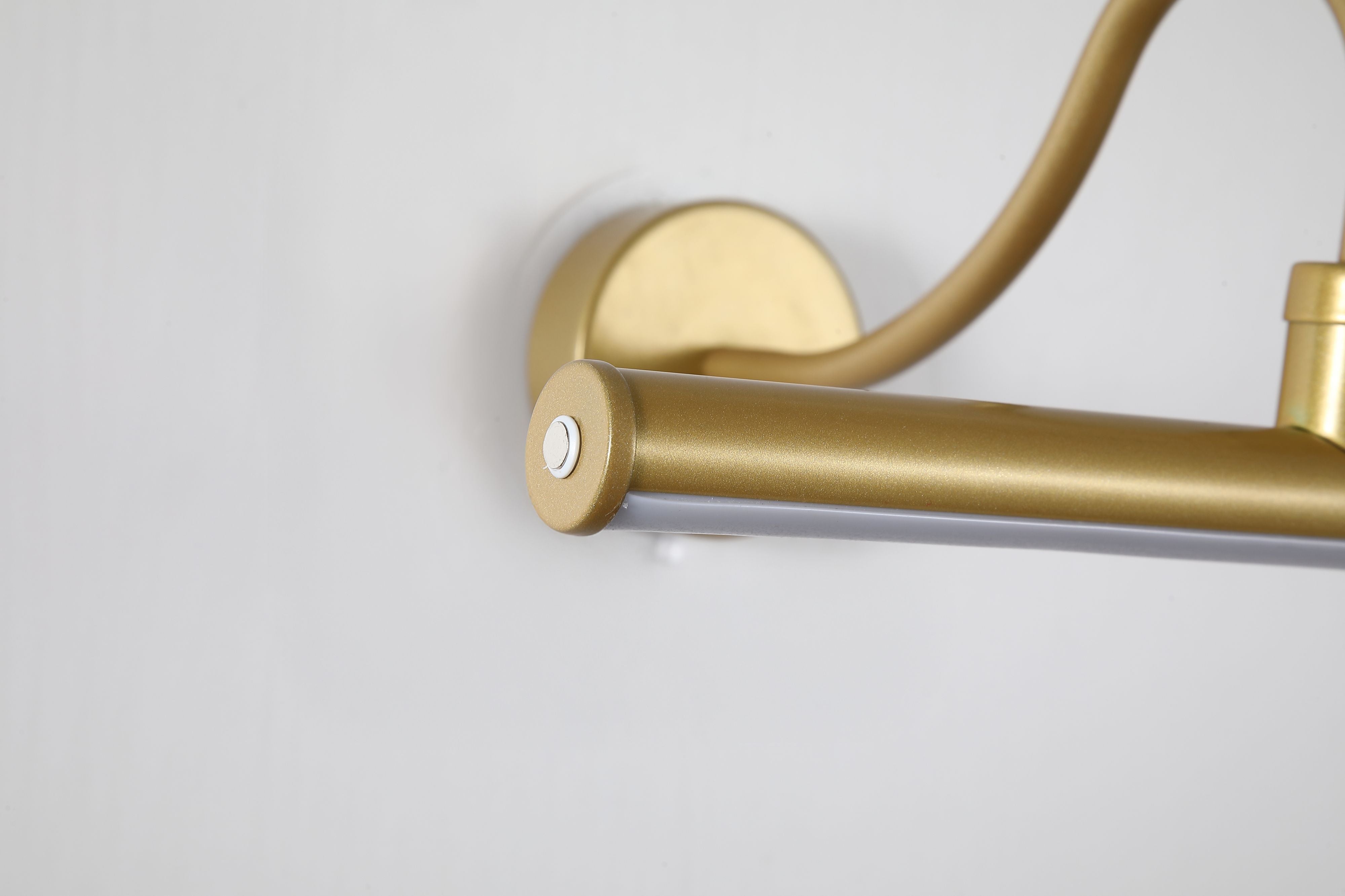 Close up of the gold Vigo picture light showing the touch dimmer button and acrylic diffuser at the end of the light bar