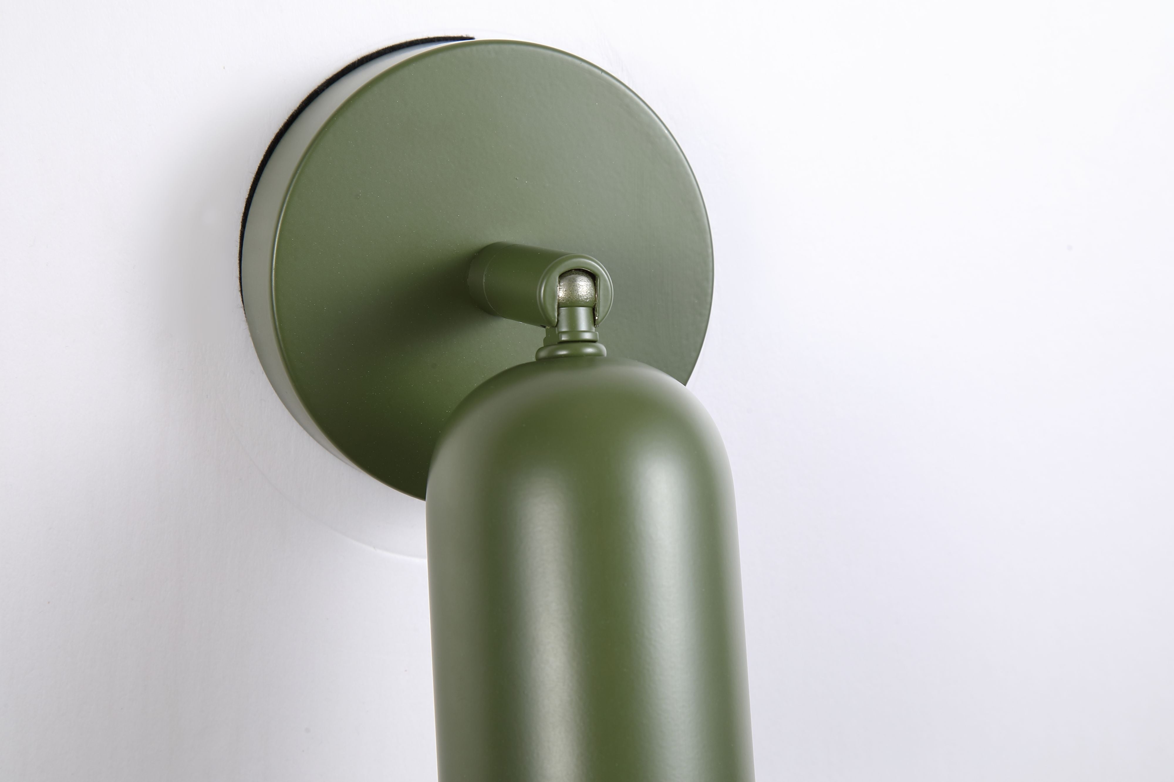 Close up of the green Cone wall light showing the wall plate and swivel joint connecting to the rounded shade