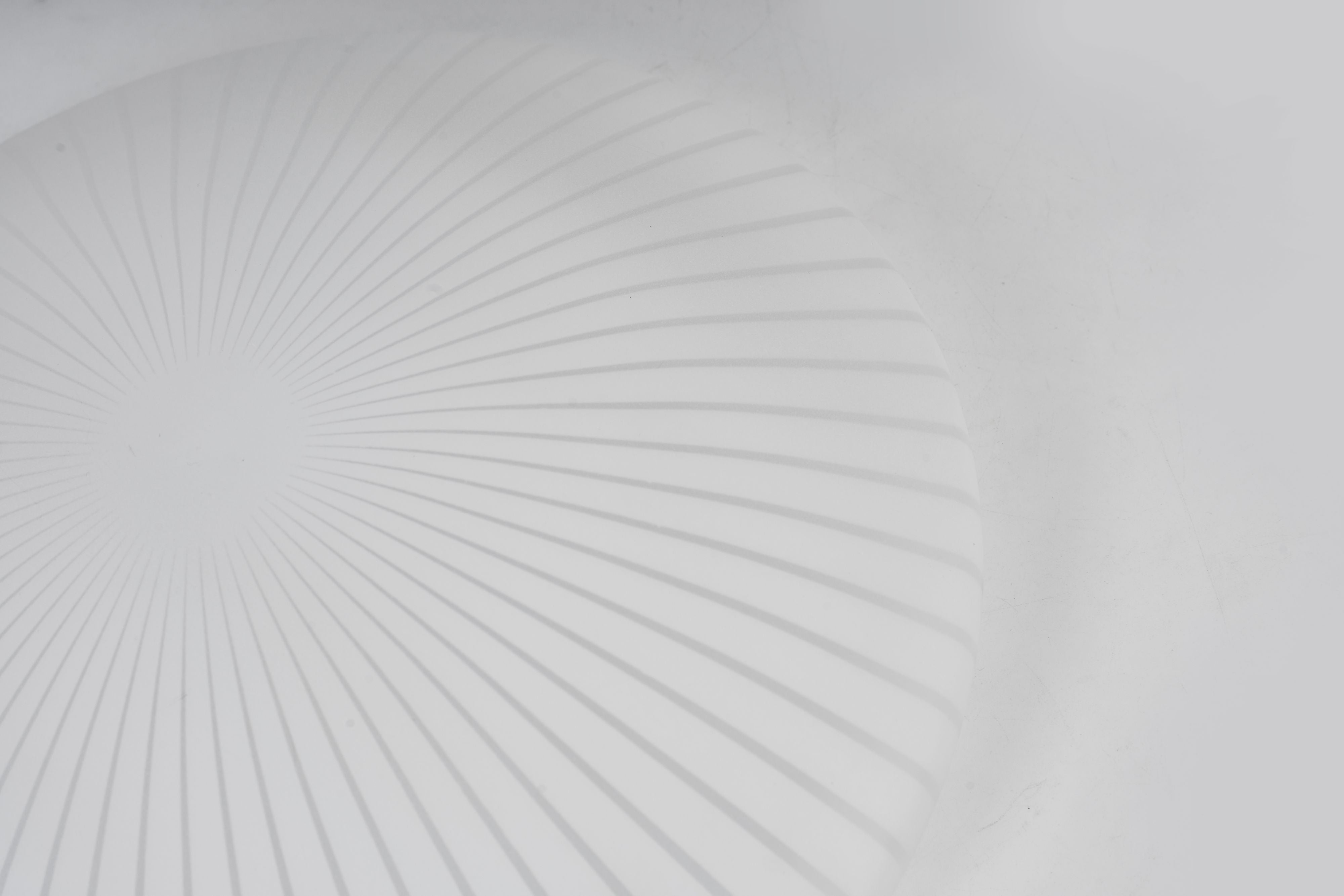 Close up angled view of the Malta 38.5cm flush ceiling light dome, showing the fine pleated ridge pattern in soft light