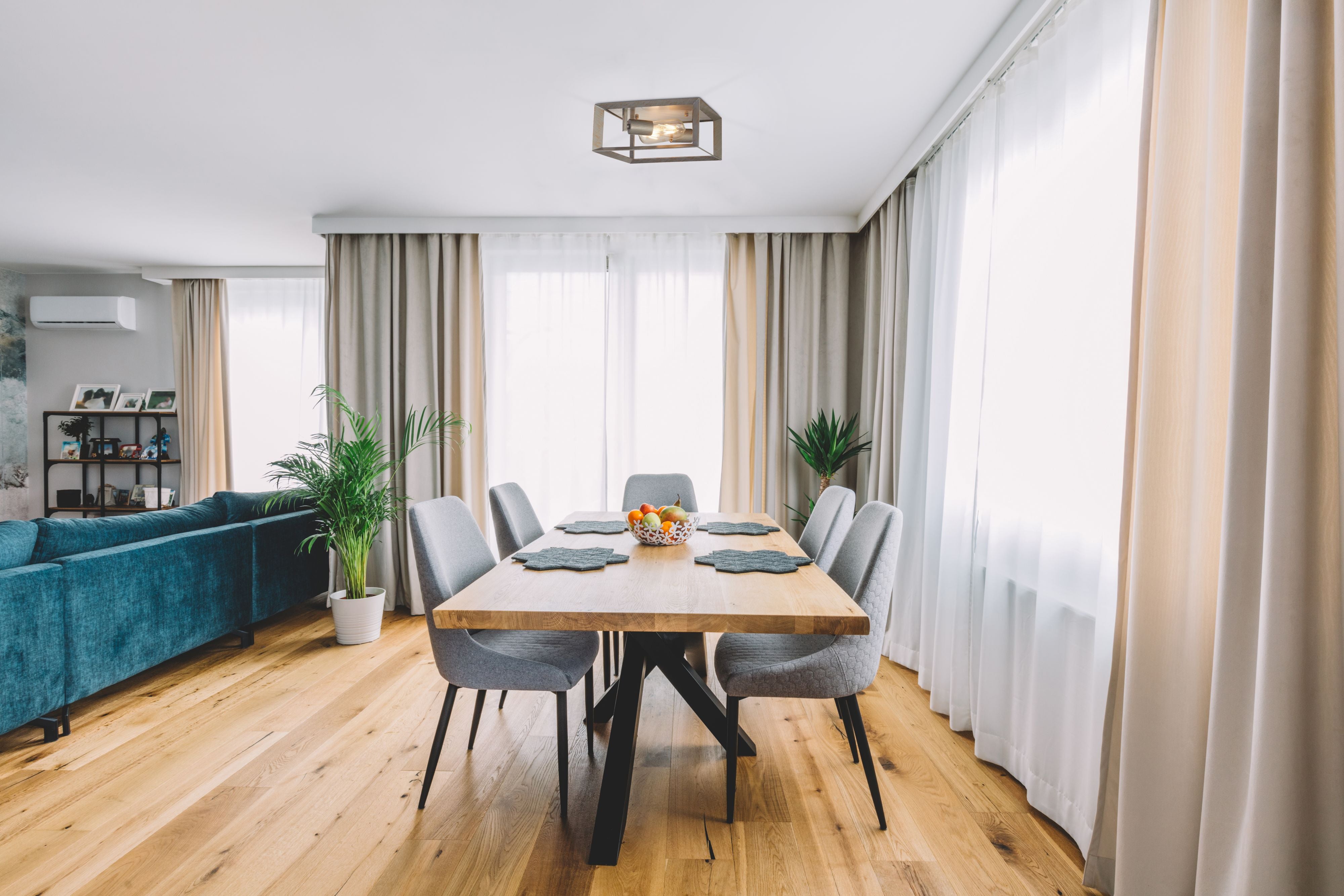 Searchlight Heaton 2 Light Flush ceiling light styled above a wooden dining table in a bright living dining room with grey upholstered chairs