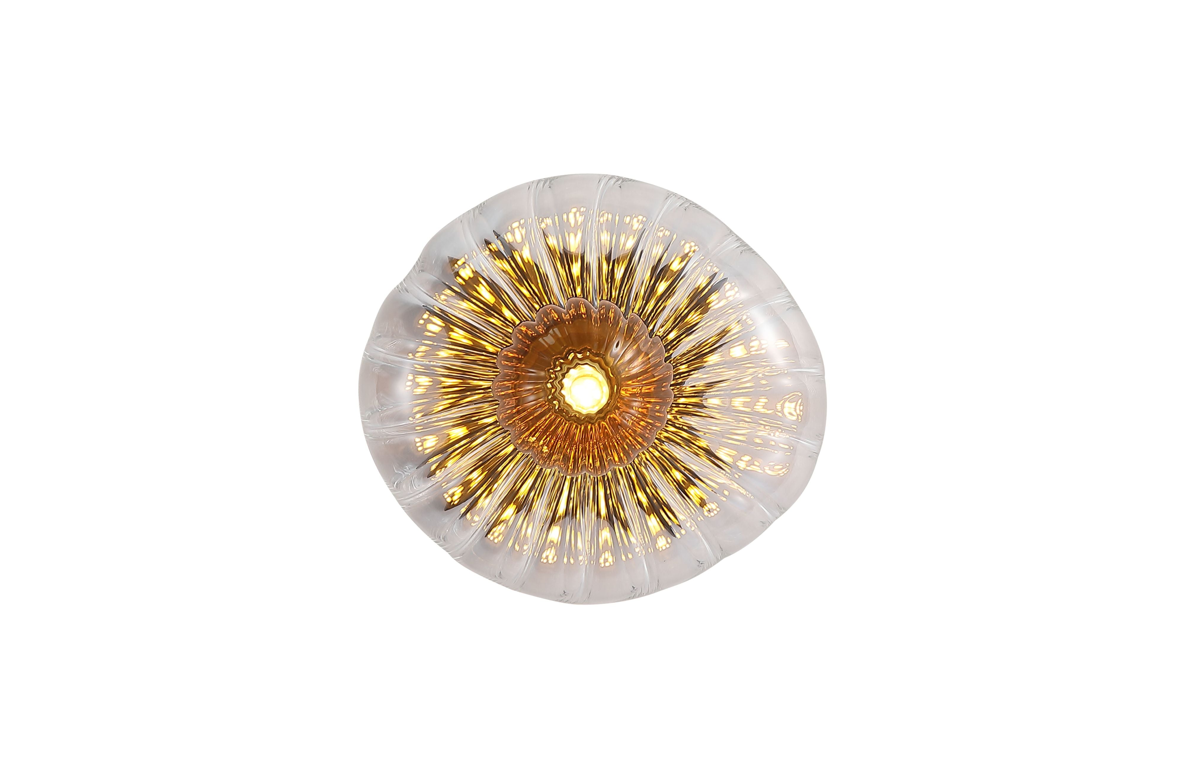Searchlight Sunbeam 1 light wall light, straight on view of the lit clear ribbed glass disc with a warm amber toned centre and radiating sunburst fluting