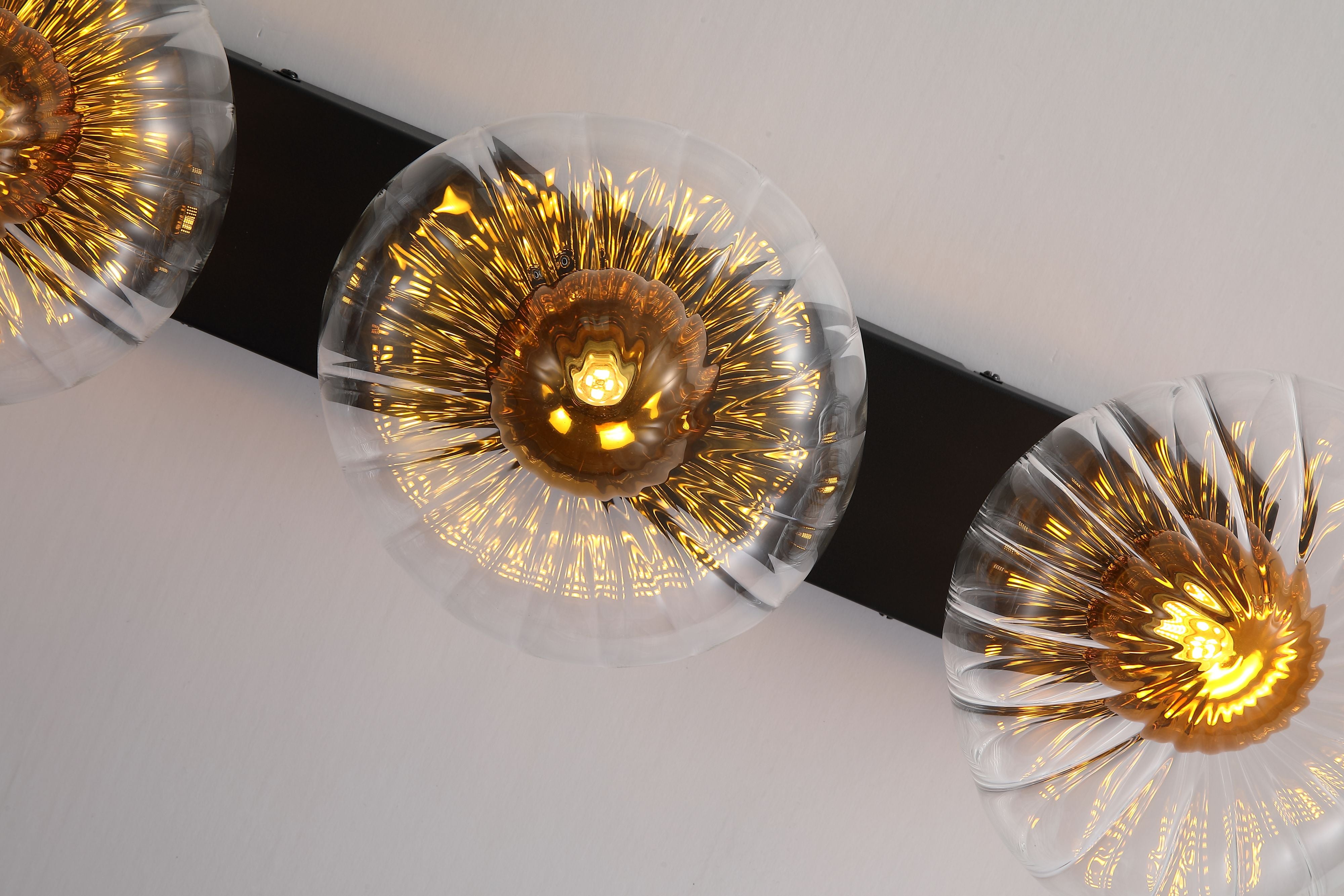 Searchlight Sunbeam 3 light wall light seen from an angle, showing the black mounting bar and fluted glass detail of each disc