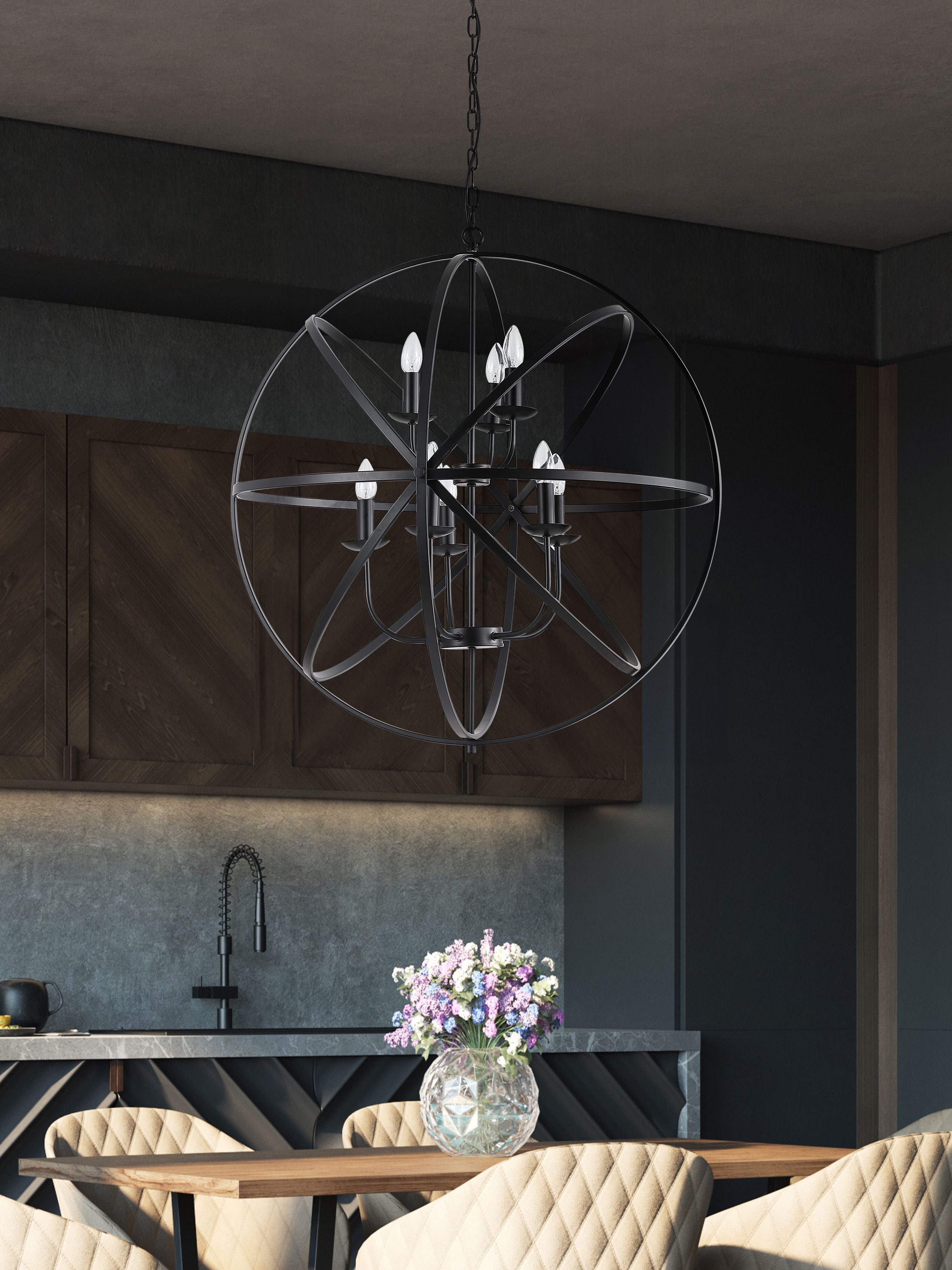 Orbit pendant in matt black hanging above a dining table in a dark modern kitchen with a floral centrepiece