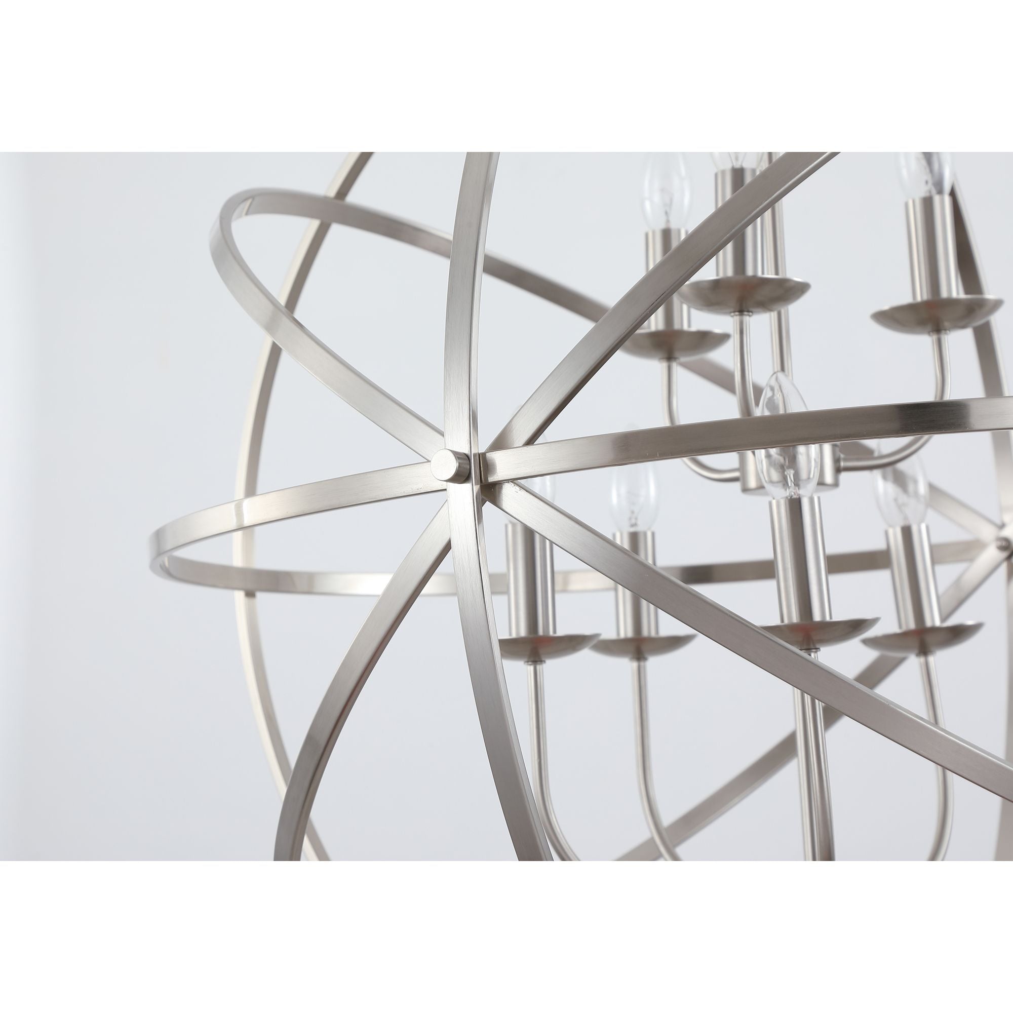 Close up of the Searchlight Orbit pendant's satin silver frame where the rings cross, showing the candle style lamp holders and bulbs at the centre