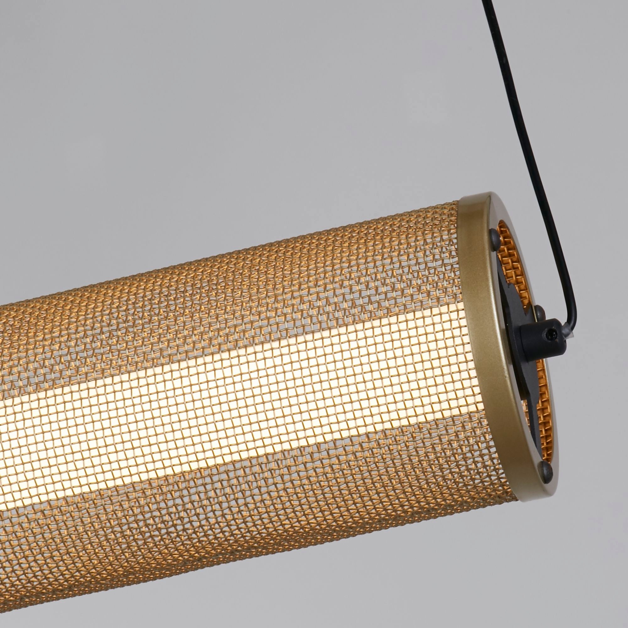 Close up of the gold mesh weave and matt black end cap on the Thread LED pendant, lit from within