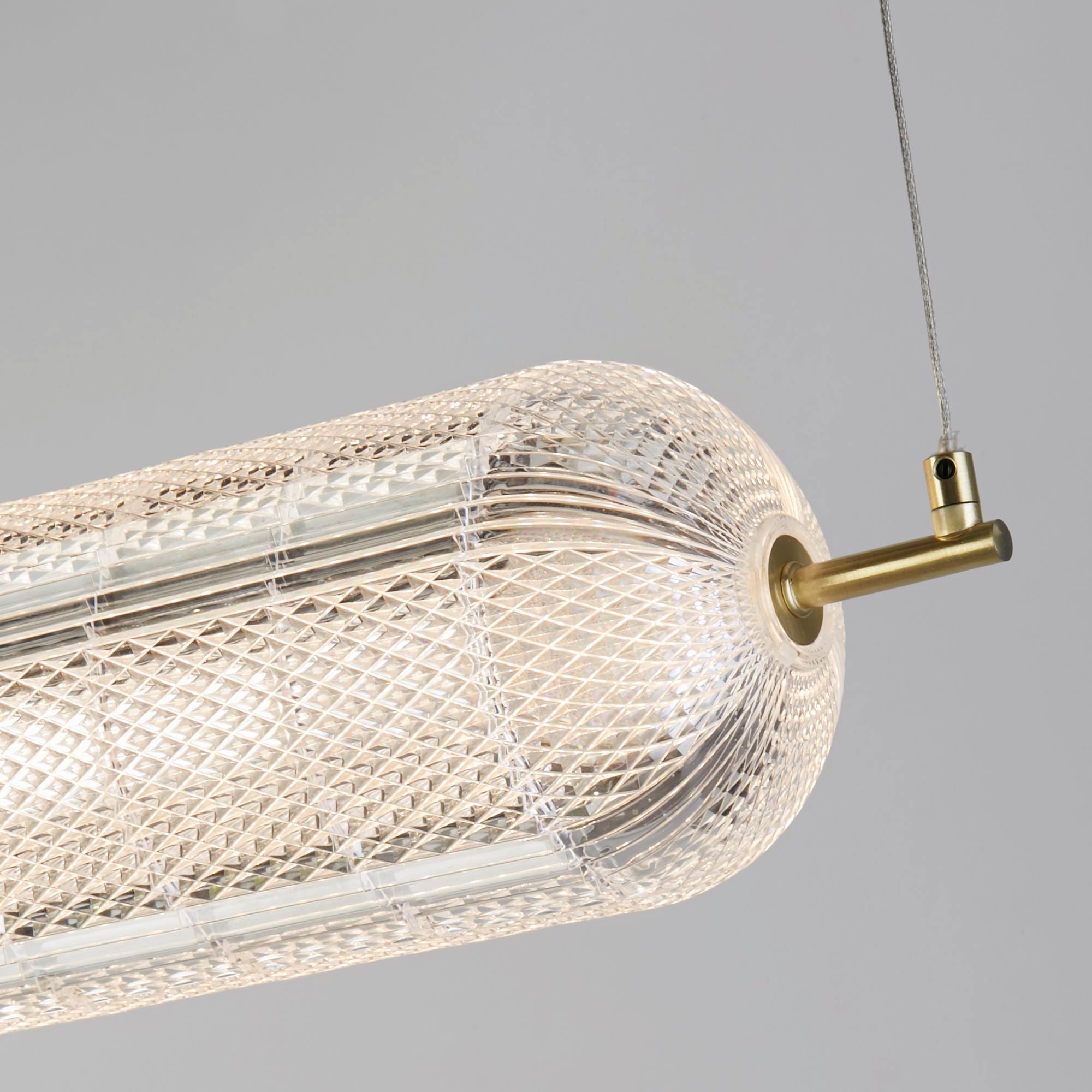 Close up of the satin brass end fitting and dimpled acrylic texture on the Capsule LED convertible pendant