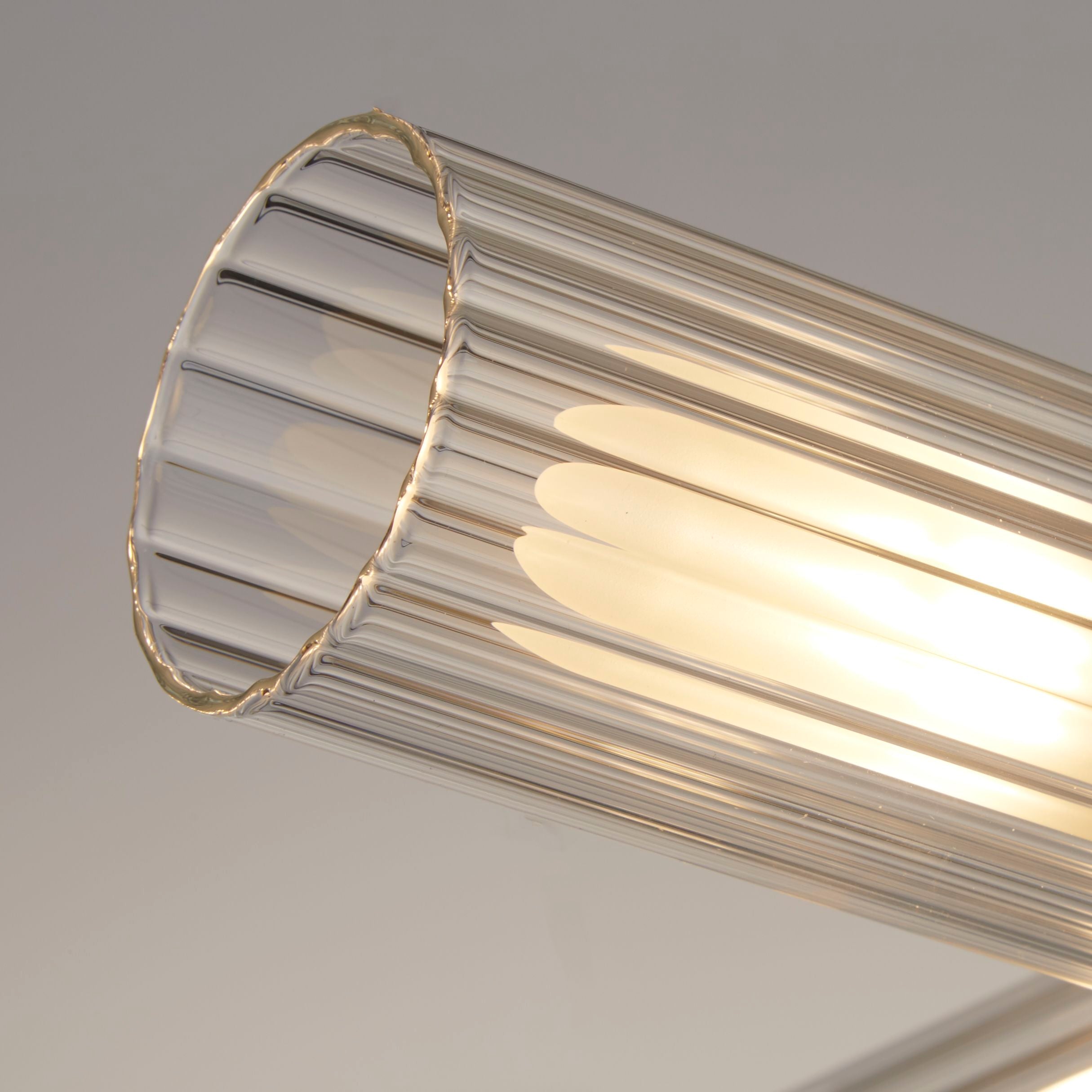 Close up of one ribbed glass shade on the Searchlight Imperial 4 Light Flush, showing the fluted texture and warm glow of the lit bulb