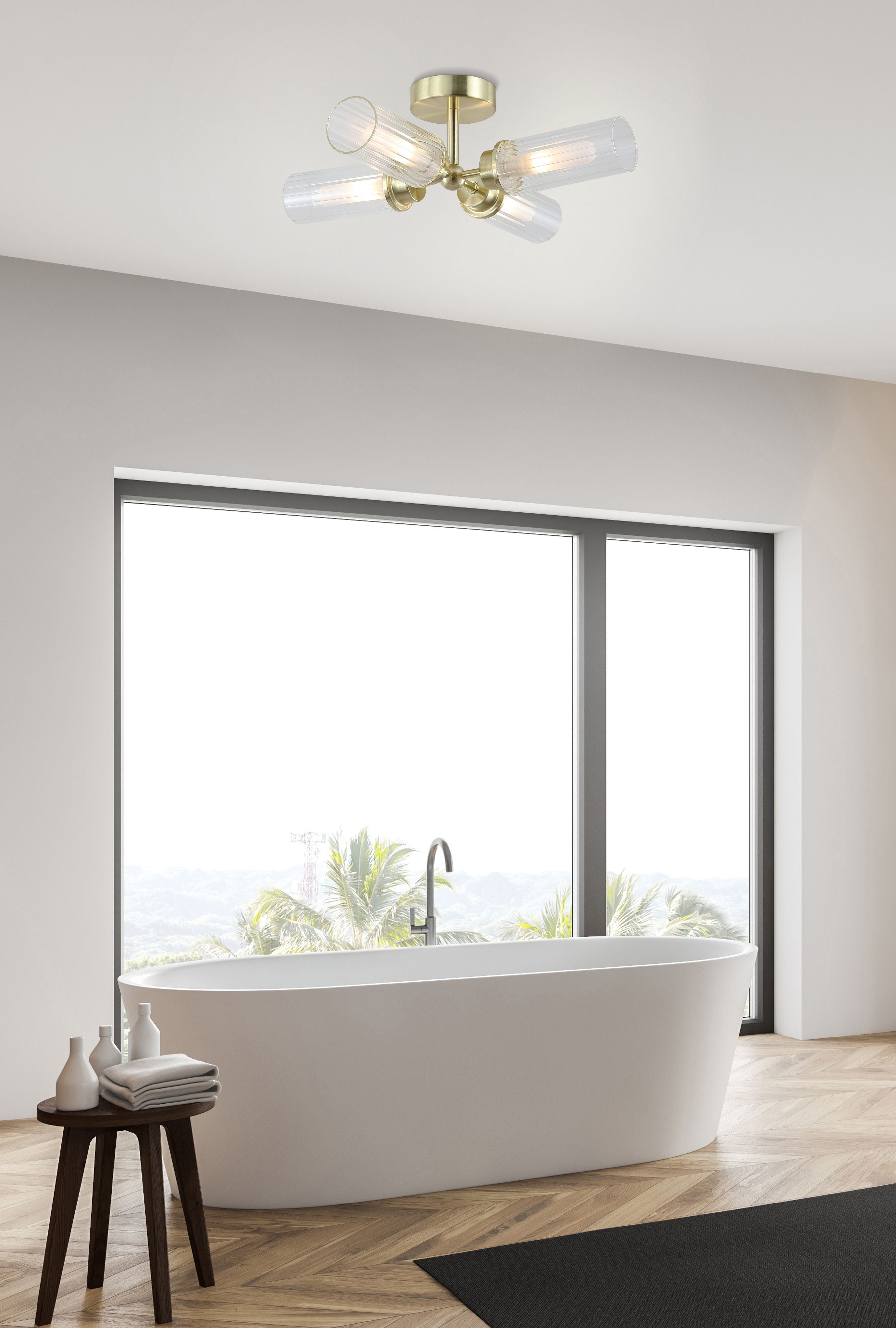 Searchlight Imperial 4 Light Flush ceiling light in satin brass styled above a freestanding bath in a light bathroom with a large window