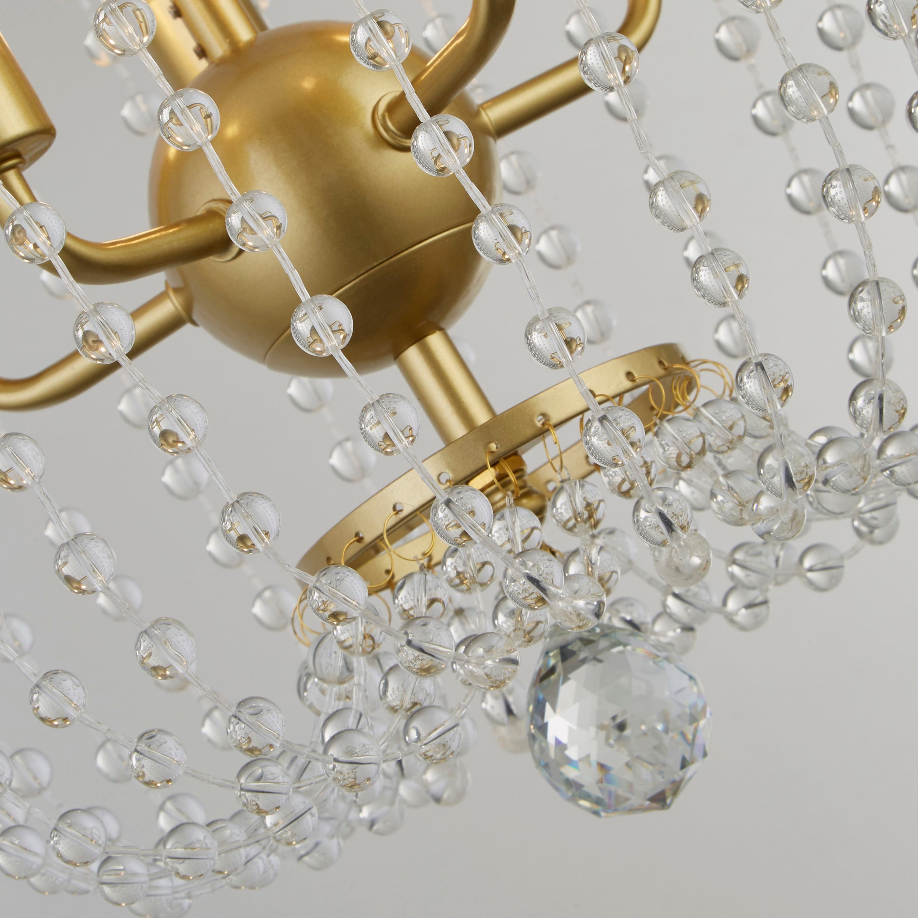 Close up of the Shower pendant's crystal bead strands and gold ceiling ring, with a faceted crystal ball drop