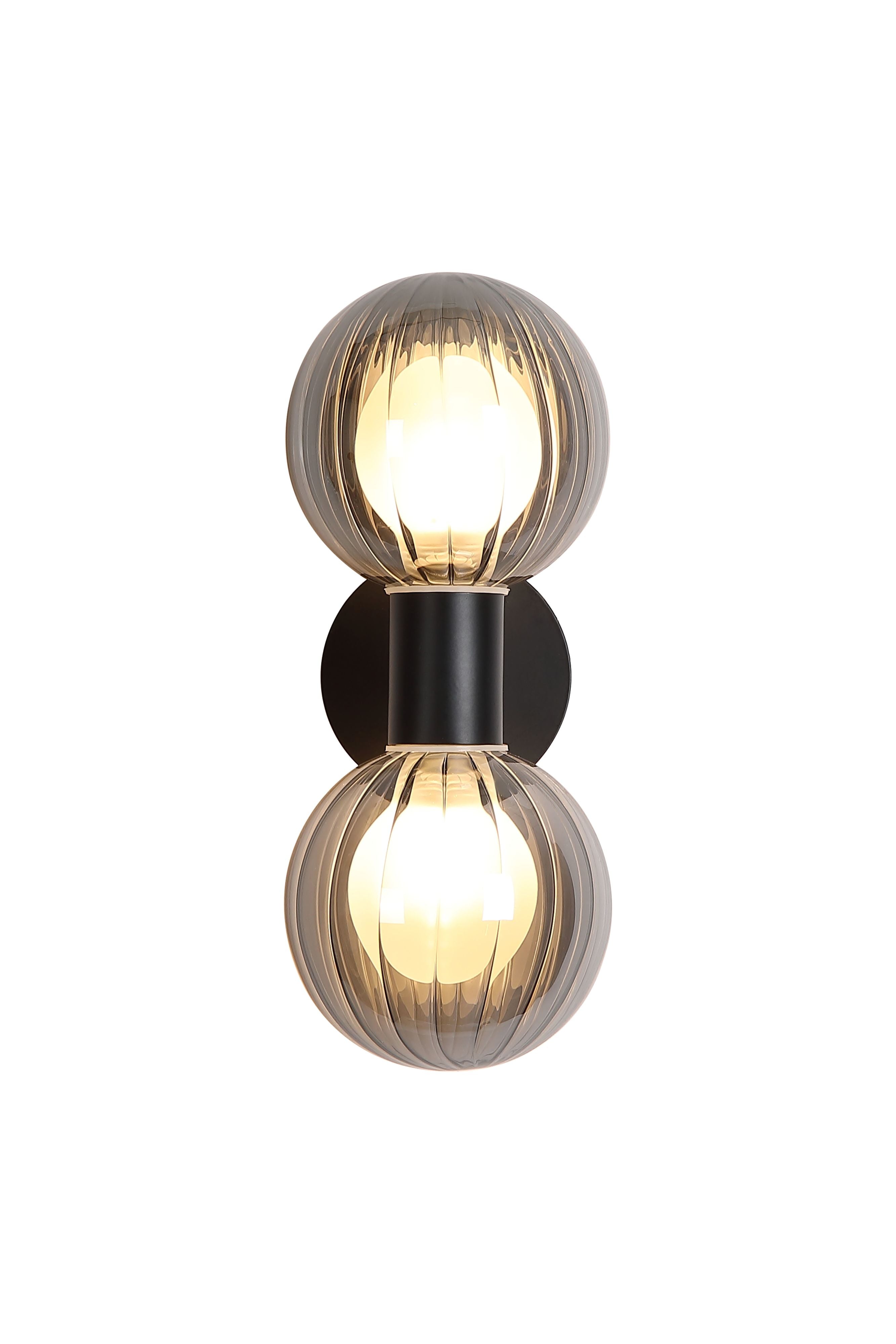 Searchlight Luminsphere 2 Light Wall Light in matte black with two smoked ribbed glass globes, lit, angled studio shot