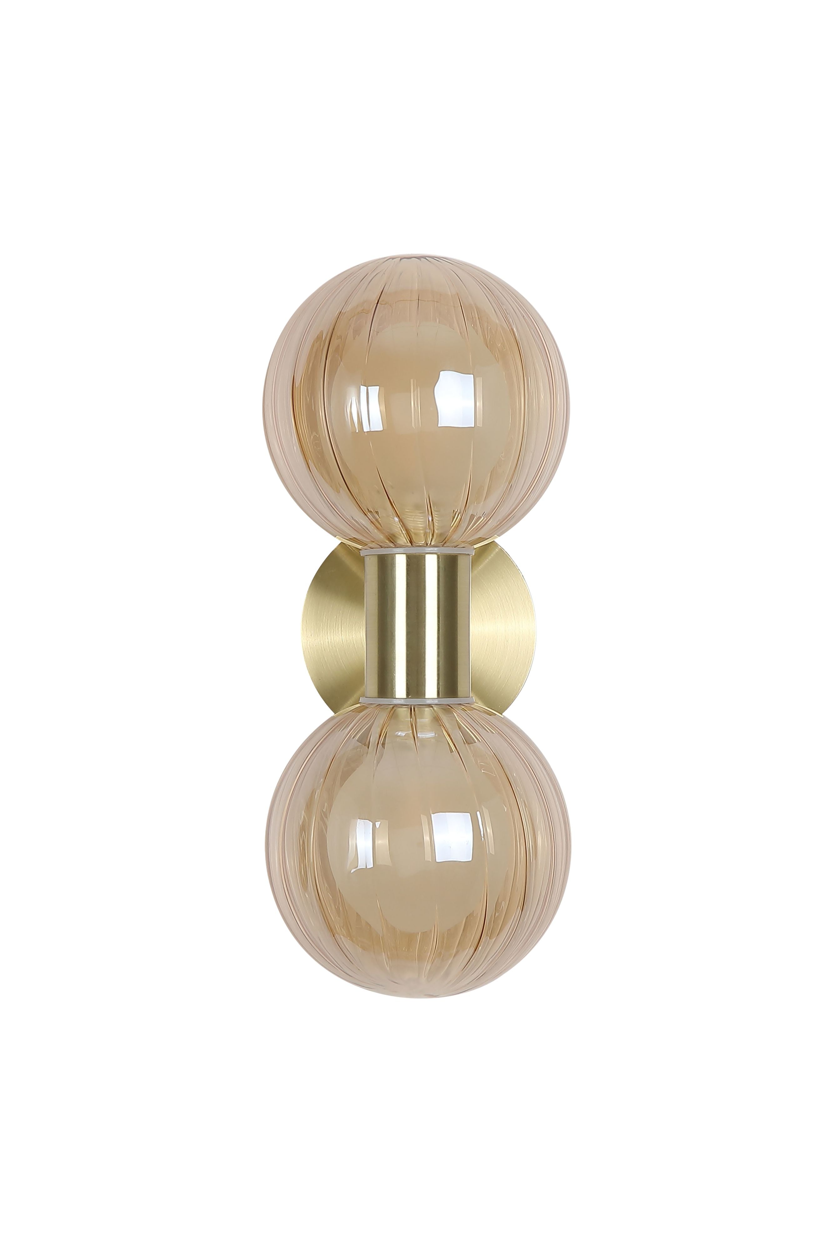Searchlight Luminsphere 2 Light Wall Light in brushed brass with two ribbed champagne glass globes, lit, front facing studio shot
