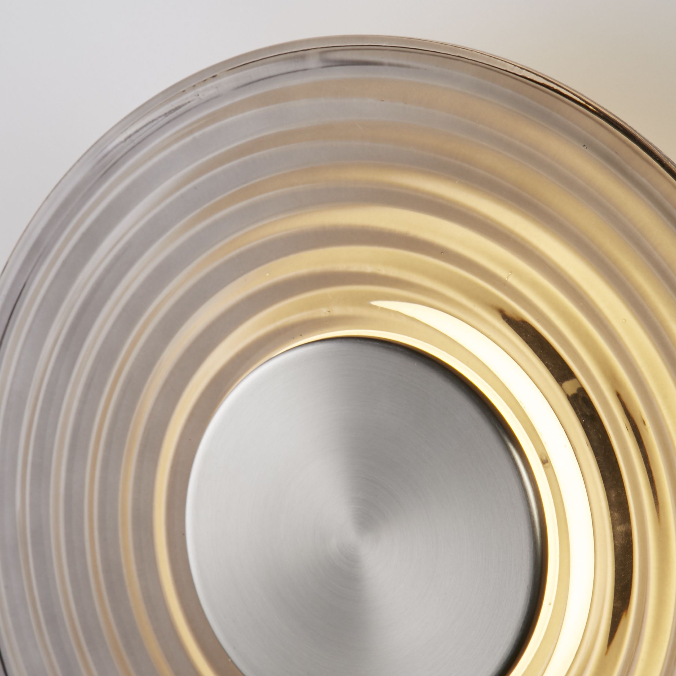Close up of the Cleo wall light's ridged grey glass and satin nickel centre disc, showing the textured rings in detail
